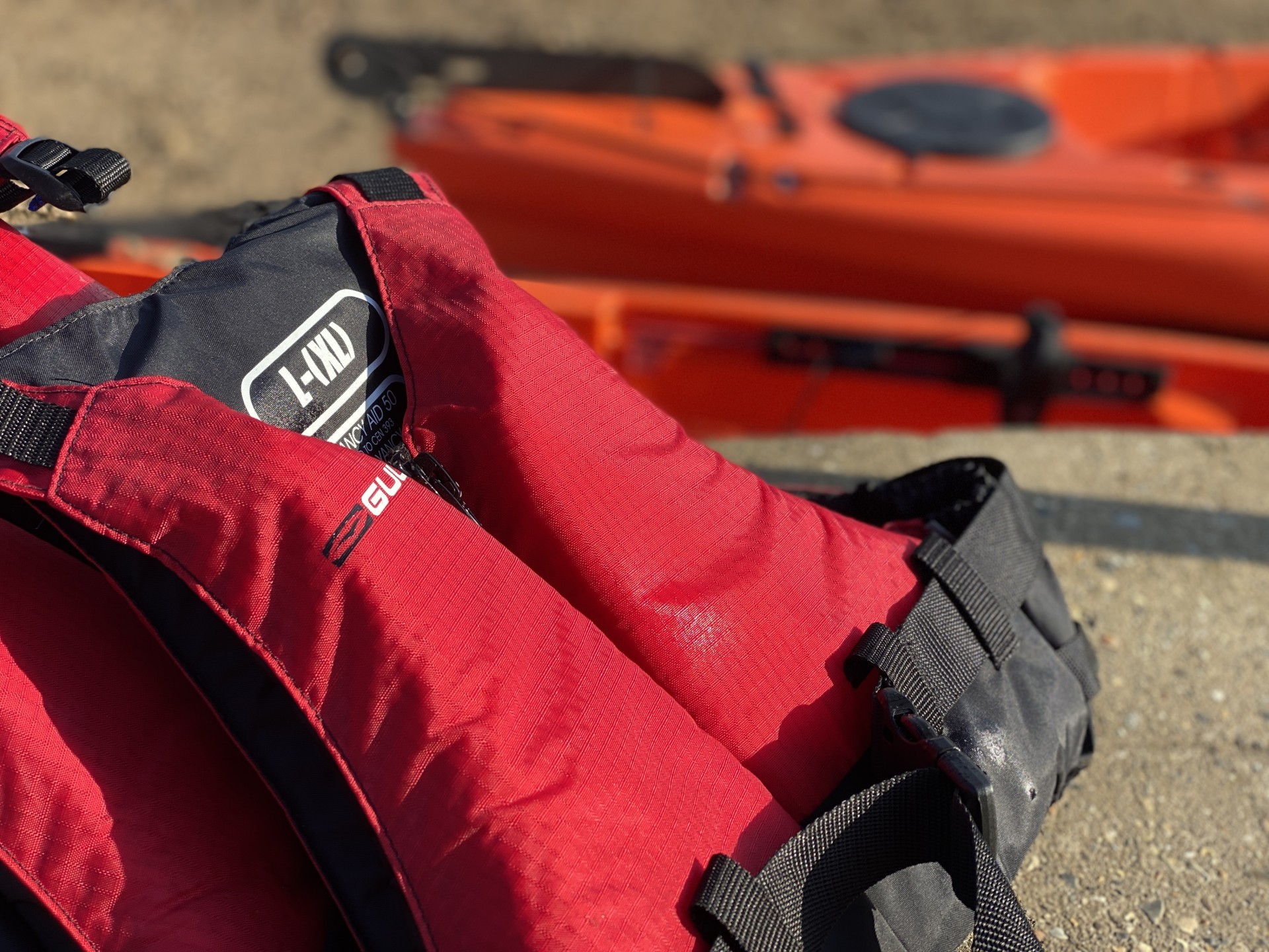 Red buoyancy aids & orange kayaks.