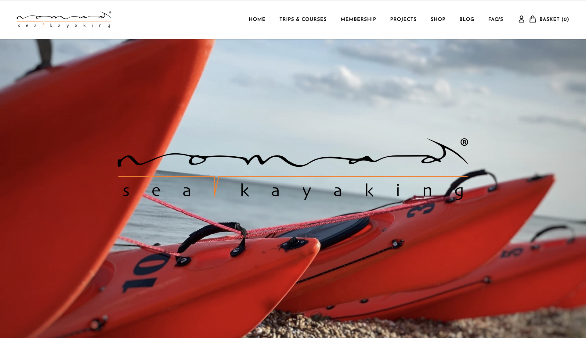 /storage/Home page of the new web site showing matching orange kayaks lined up on a shingle beach with blue skies in the background.