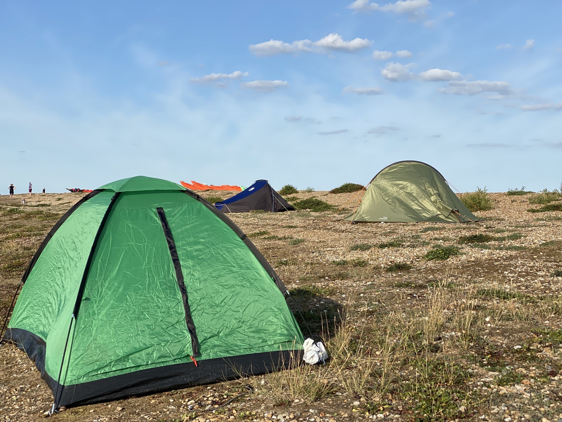 Green tents on a beach provided for the 'all inclusive' wild camping trips.