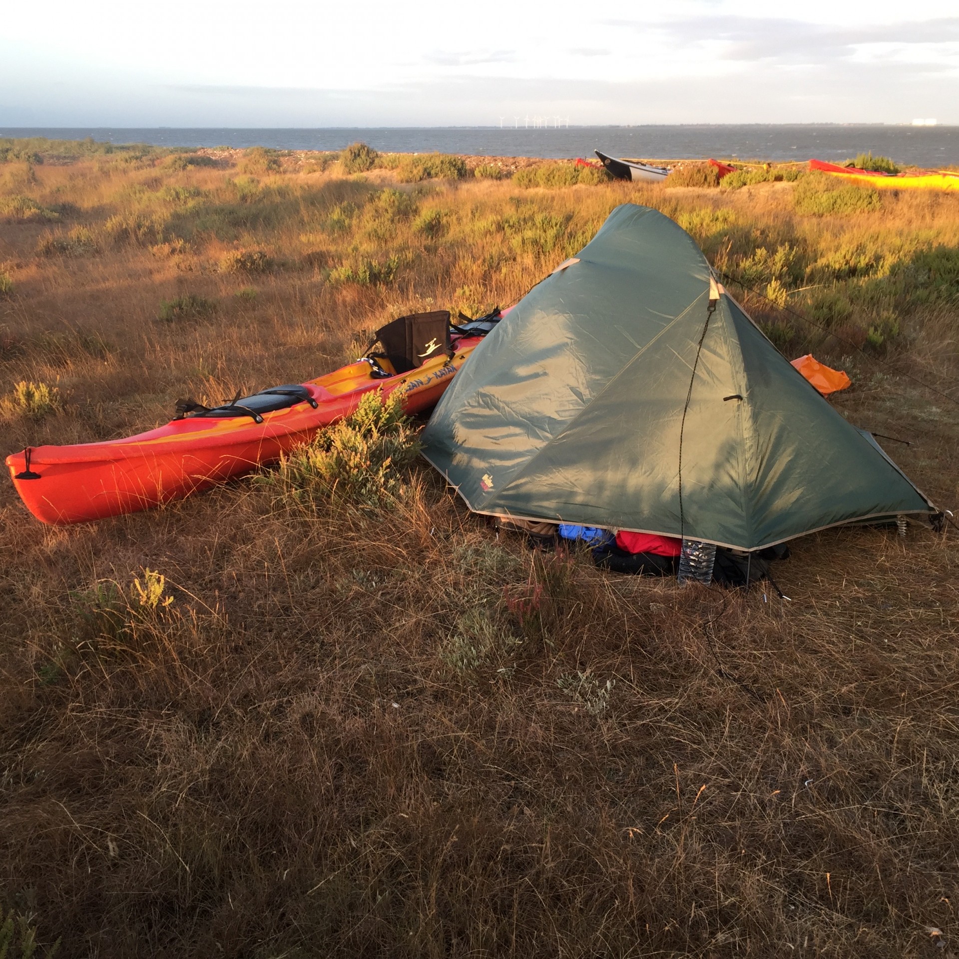 Sea kayak and tent on the beach wild camping.