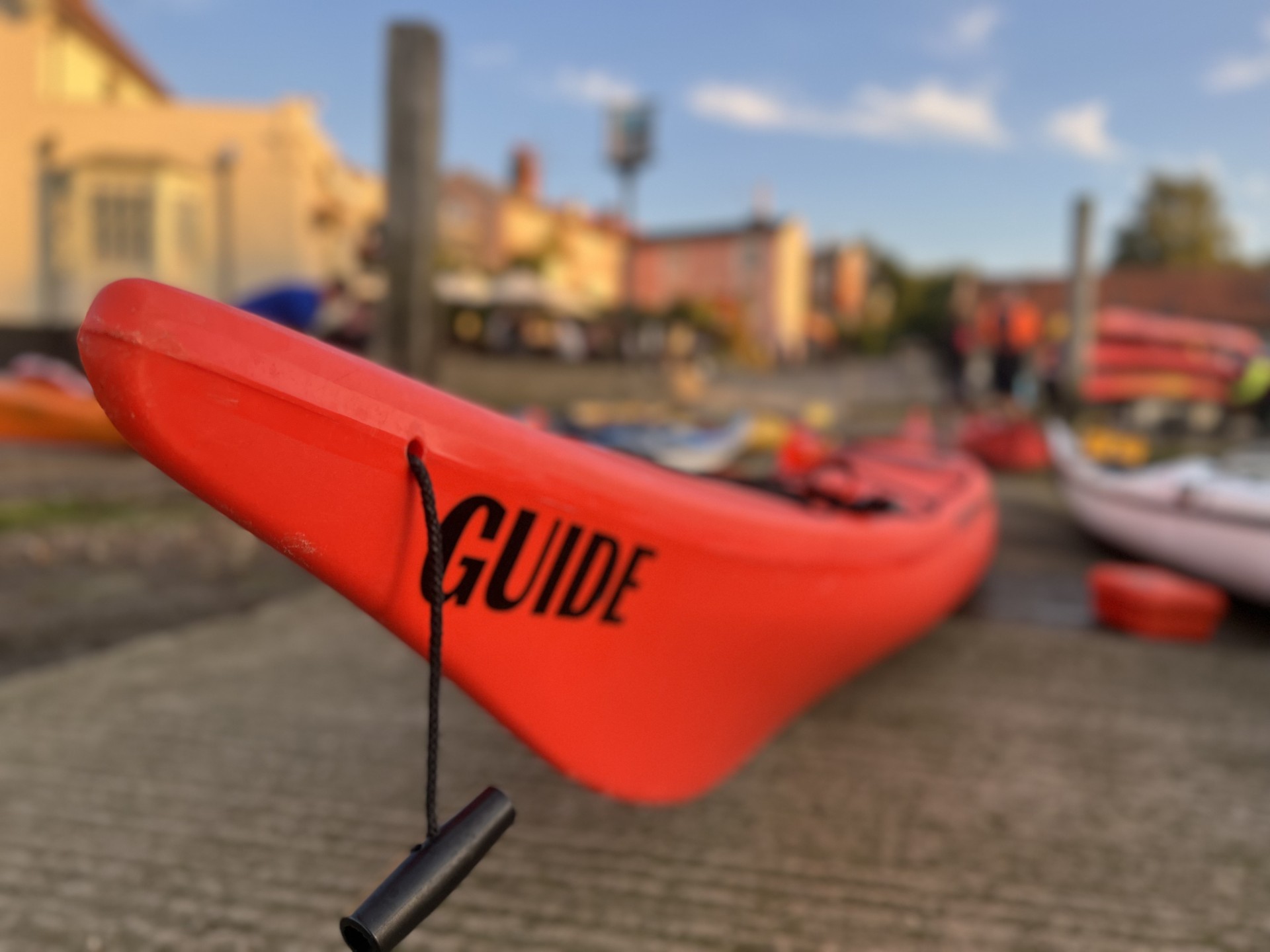 Orange sea kayak with 'Guide' on the bow.