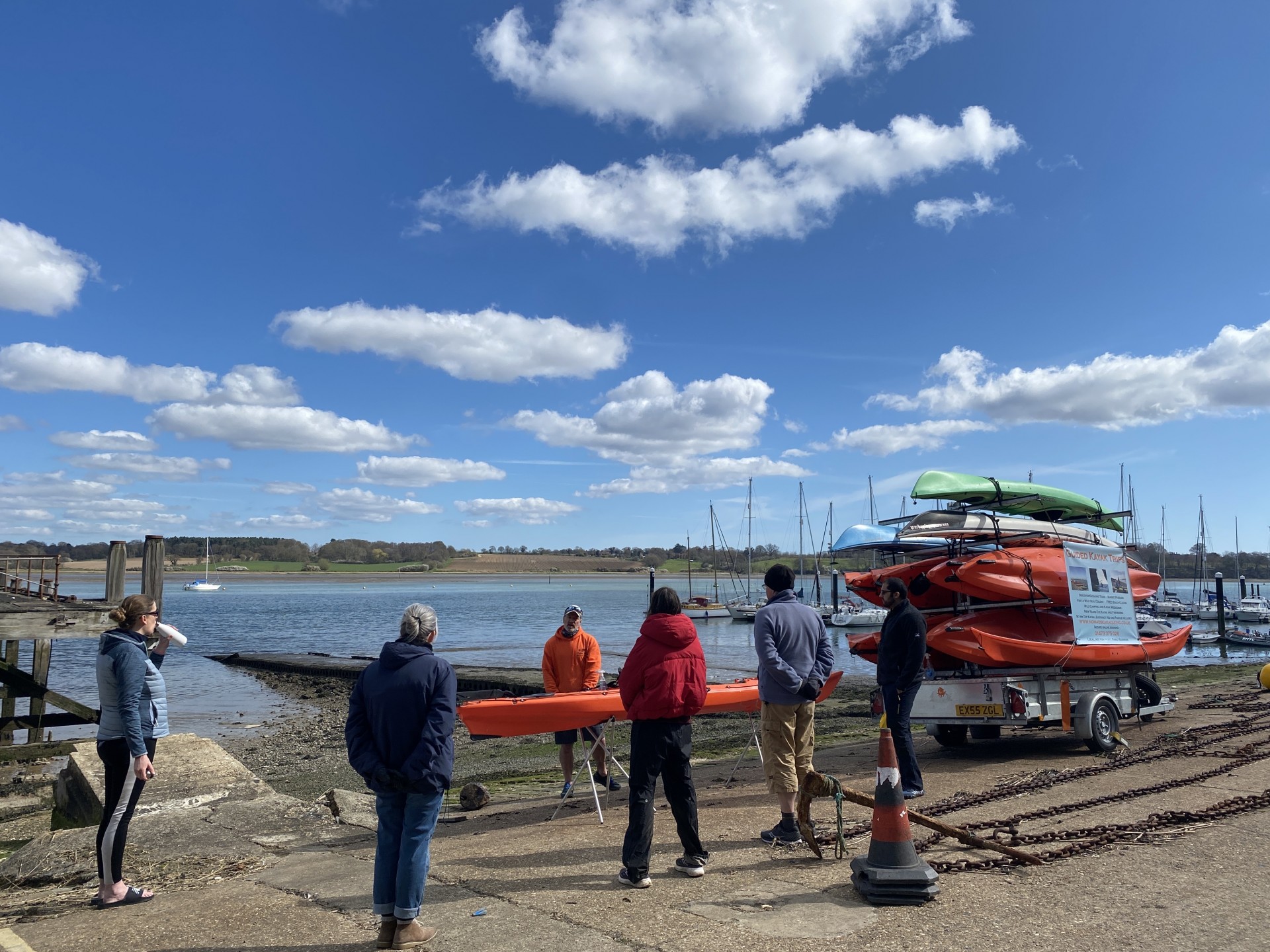 Kayaking students near the waters edge taking guidance on kayaks.