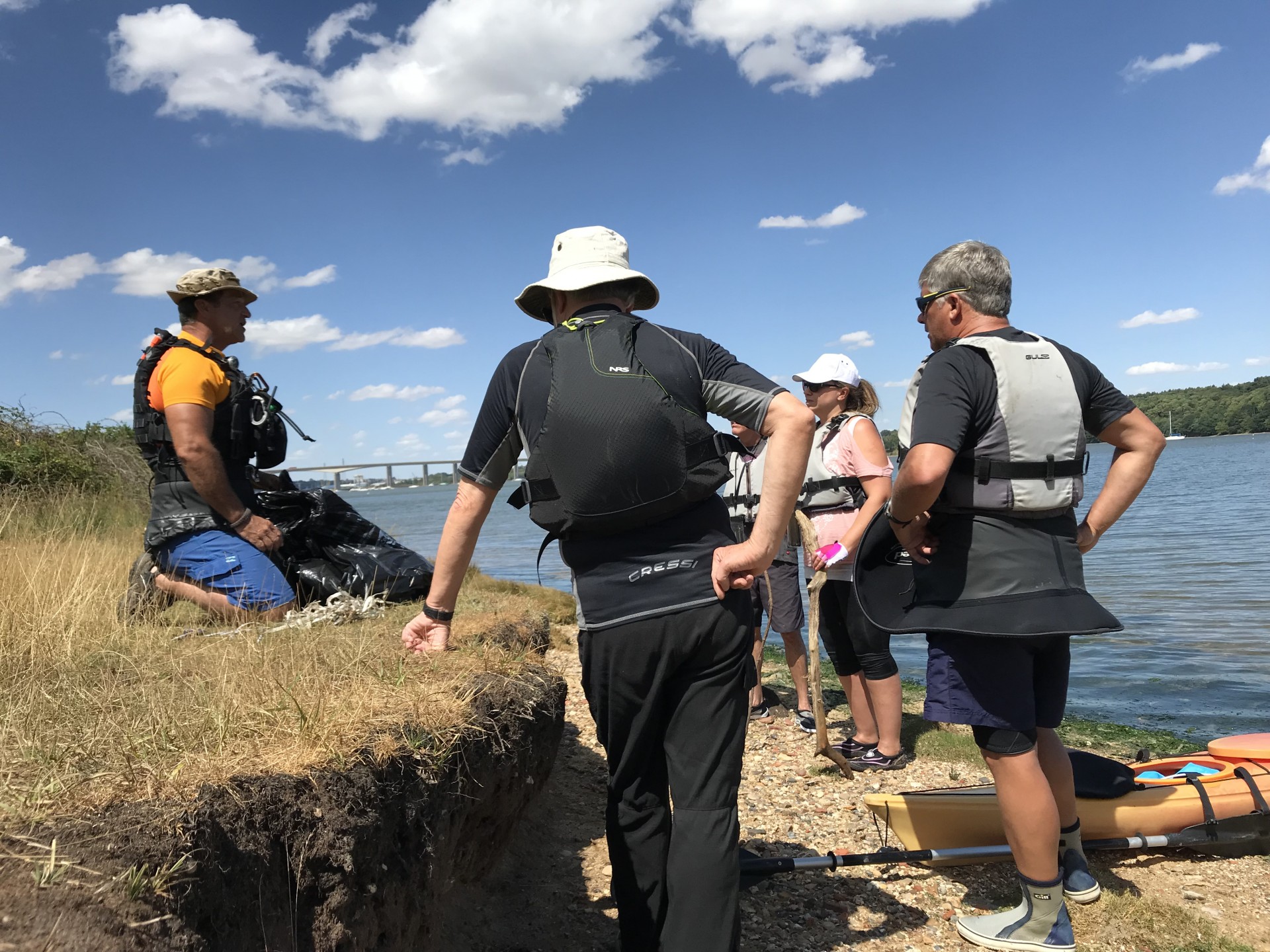 A small group stands on a beach during a team building event for business