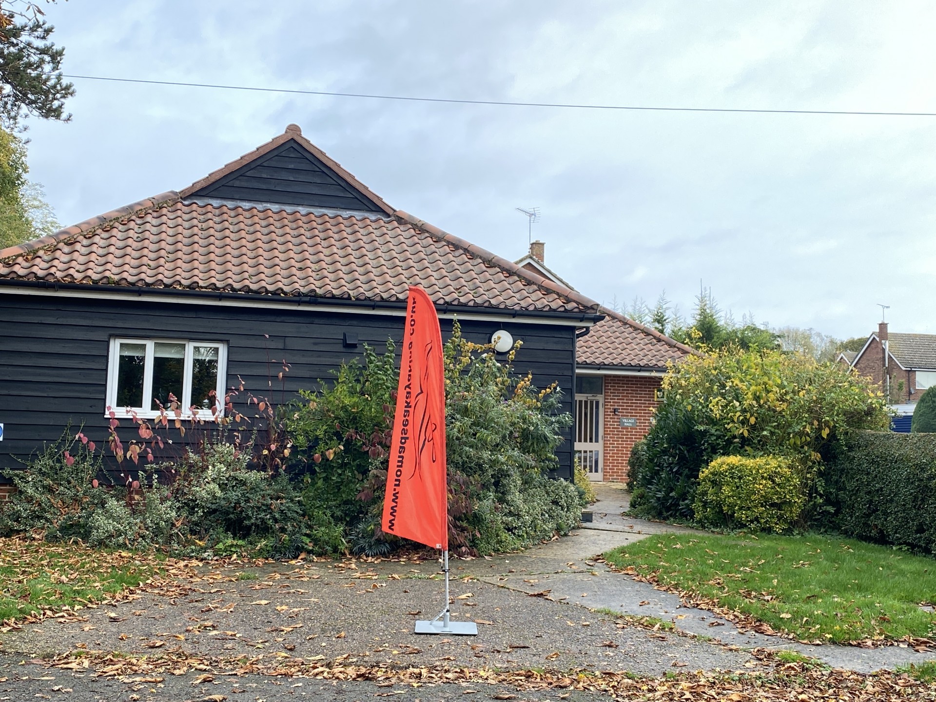 A village hall with a tall orange flag outside