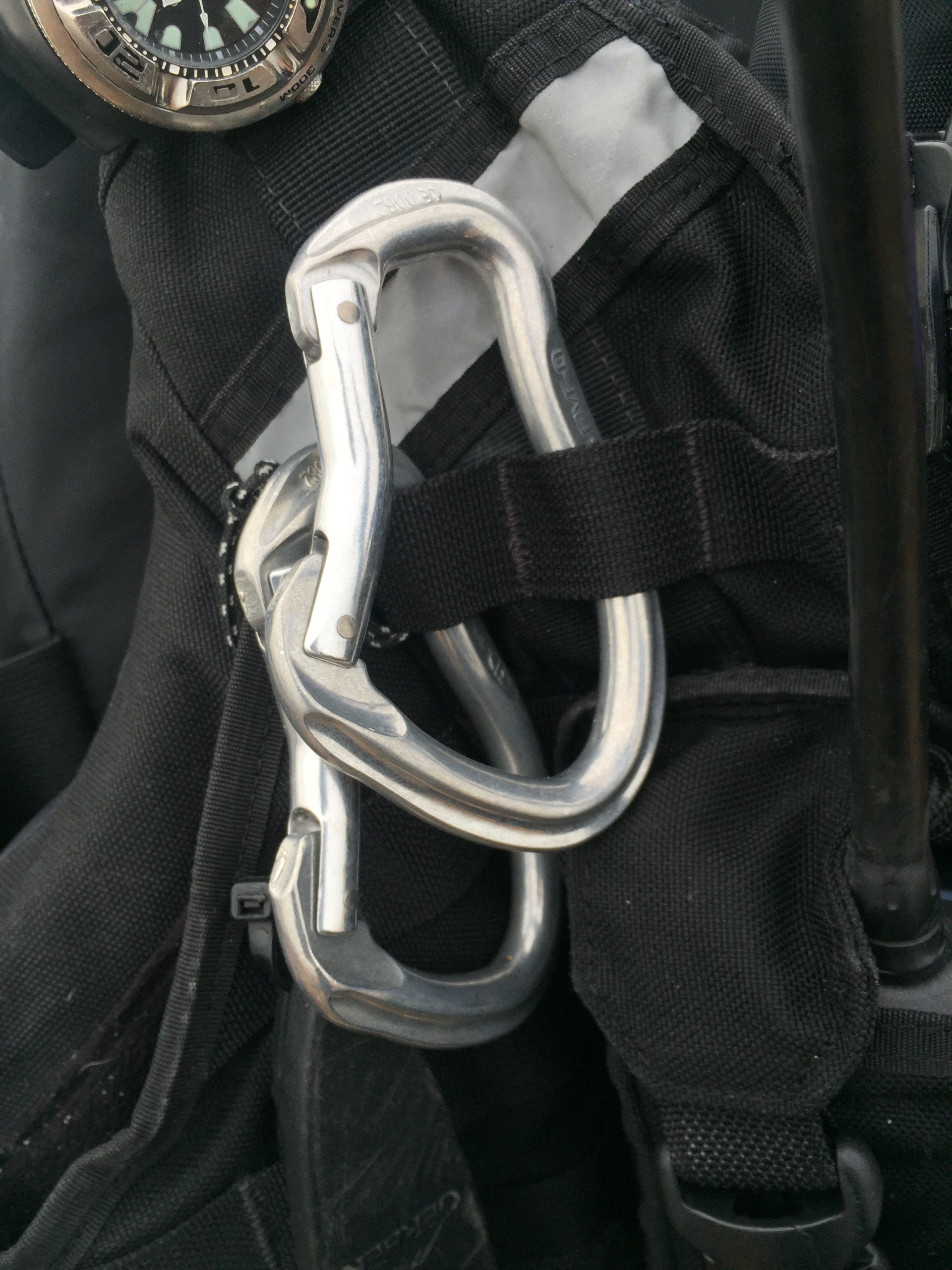 Spare carabiners on a black buoyancy aid for sea kayakers with NOMAD Sea Kayaking.