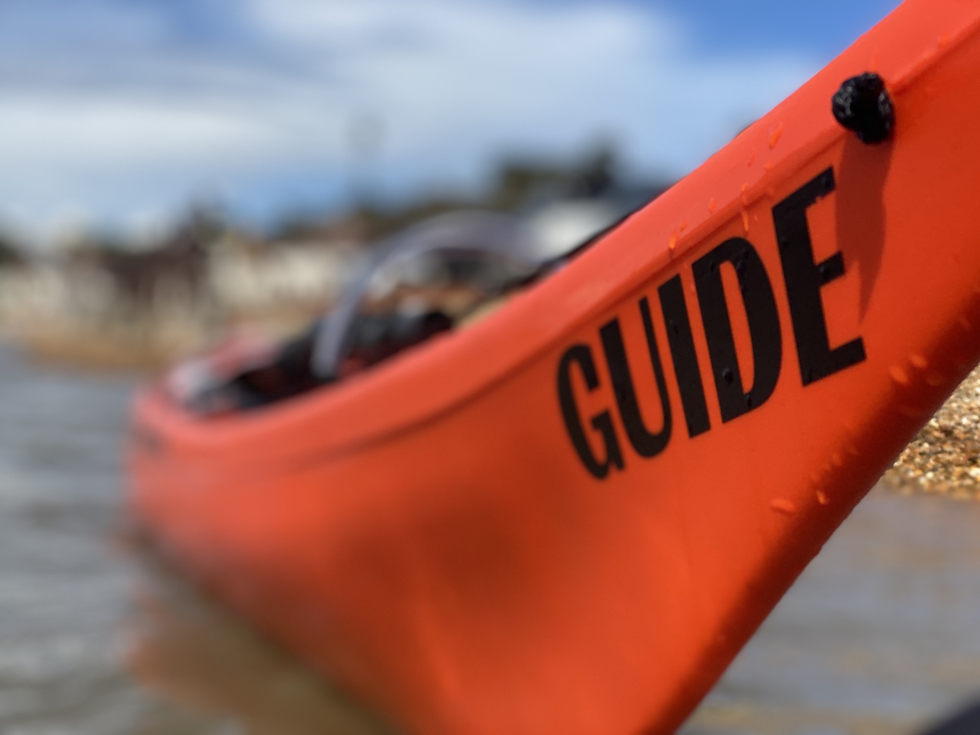 Bow of orange sea kayak NOMAD Sea Kayaking.