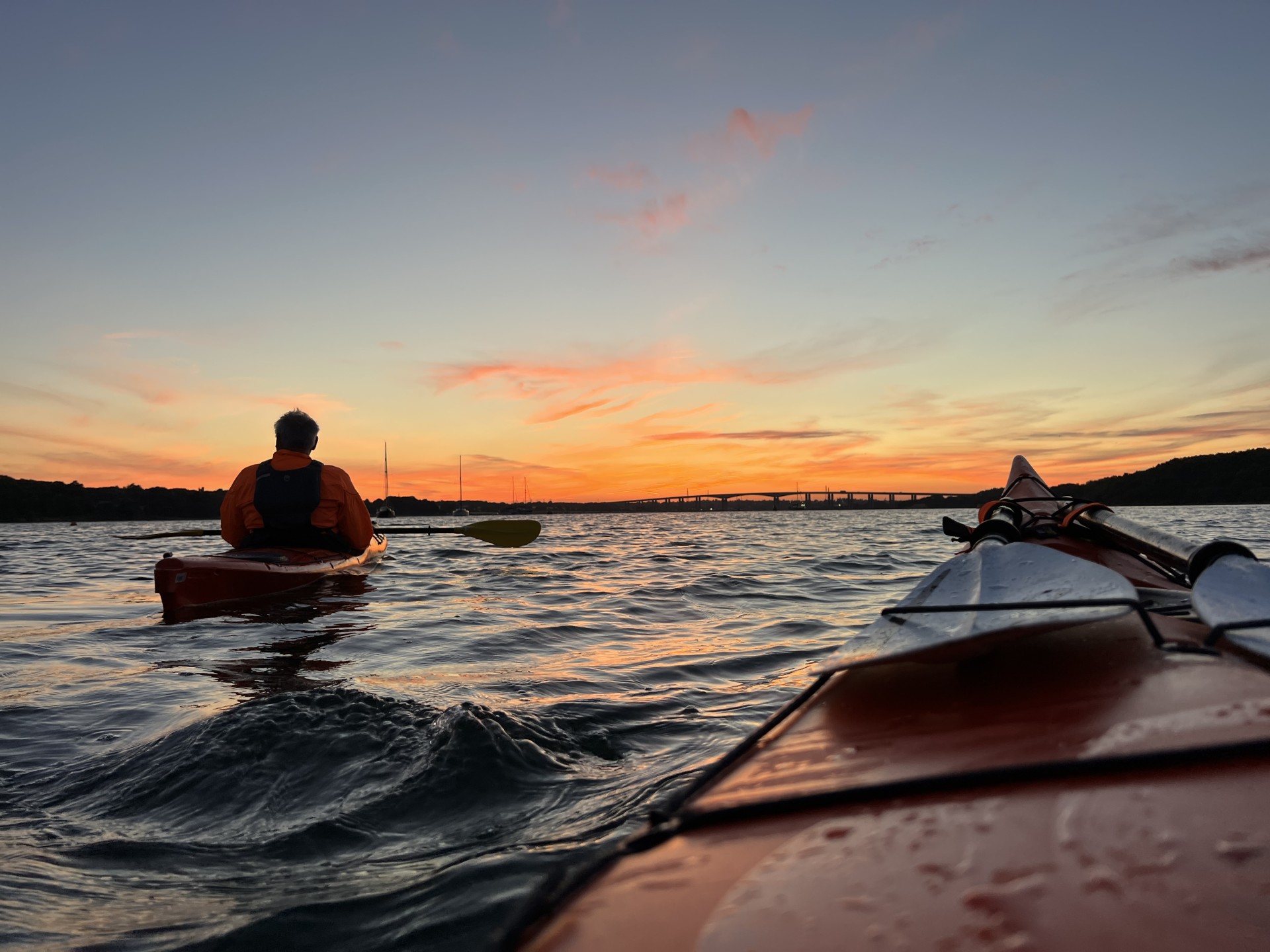 Kayakers at sunset with NOMAD Sea Kayaking.