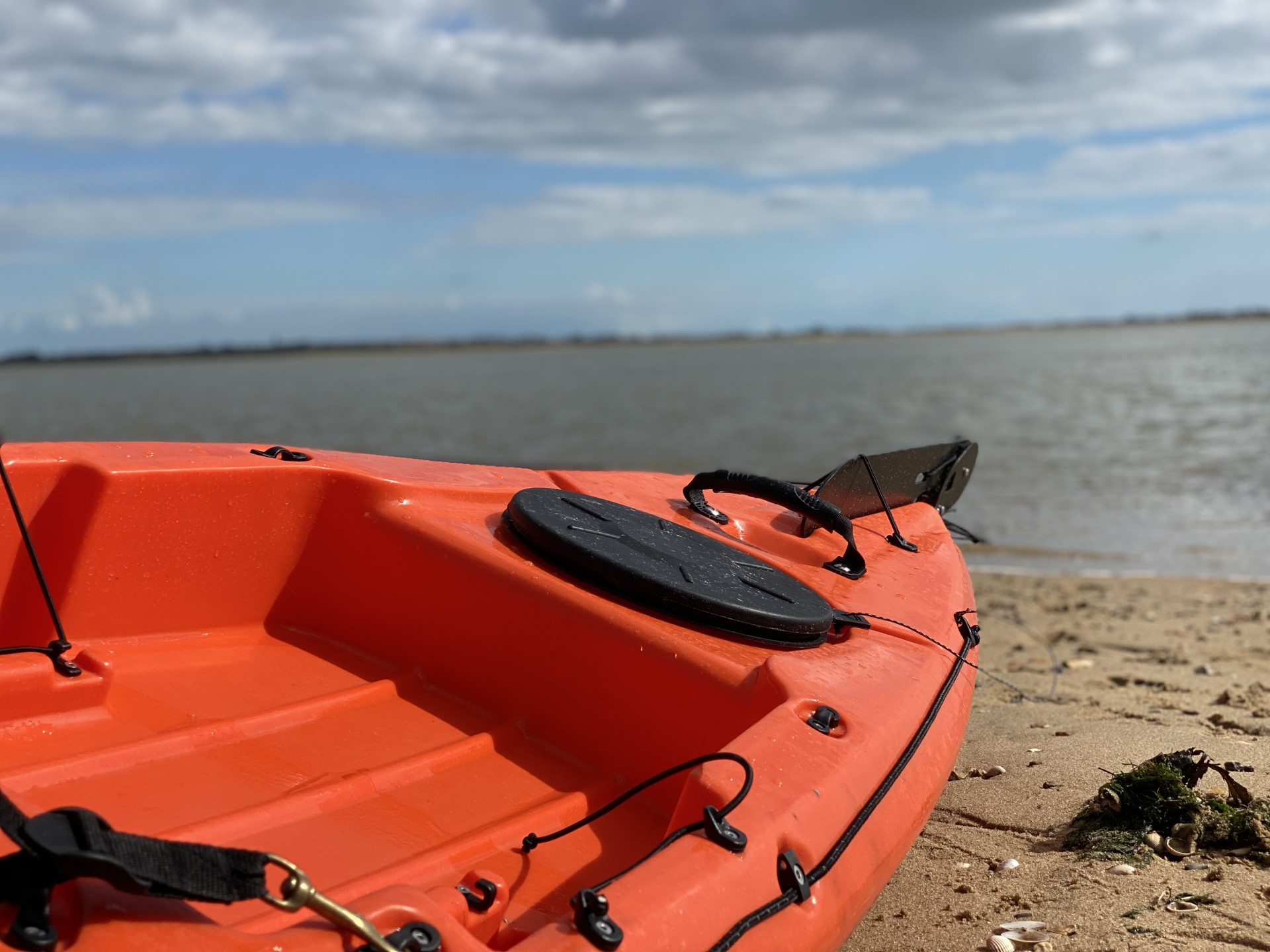 The stern of an orange sit-on-top kayak.