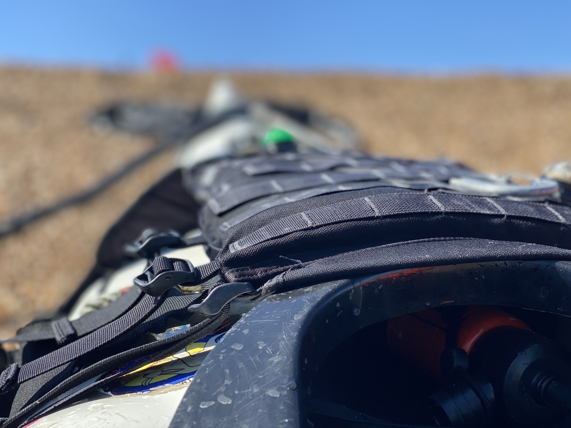 A black buoyancy aid lying across a white sea kayak.
