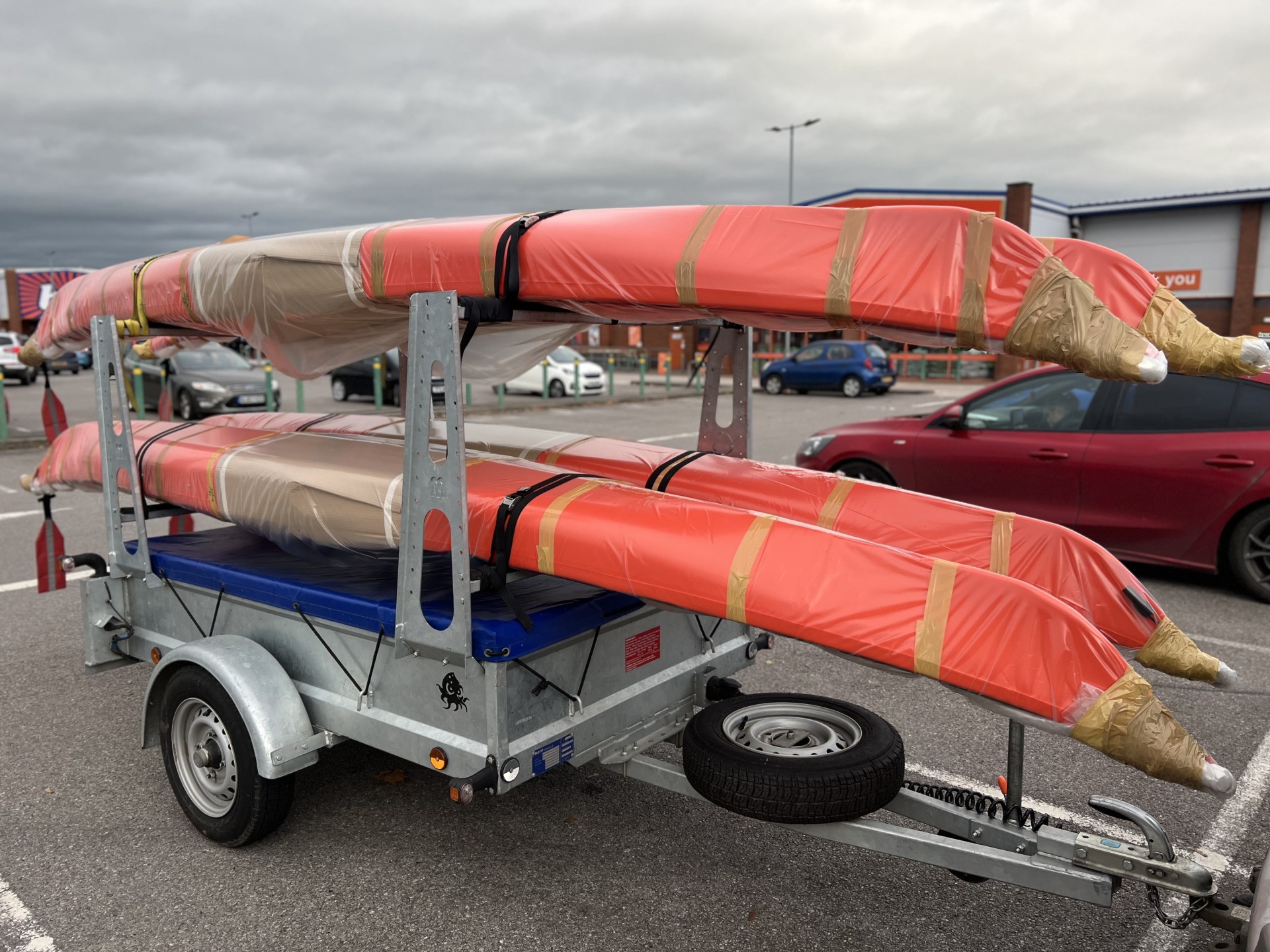 New sea kayaks in packaging being transported by trailer.