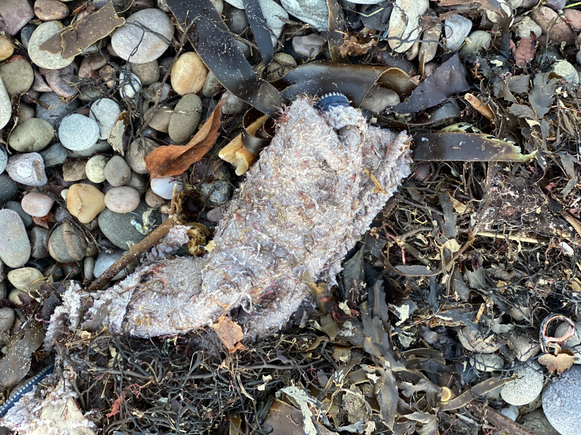 Unidentifiable refuse on a Suffolk beach, beach cleaning with NOMAD Sea Kayaking.