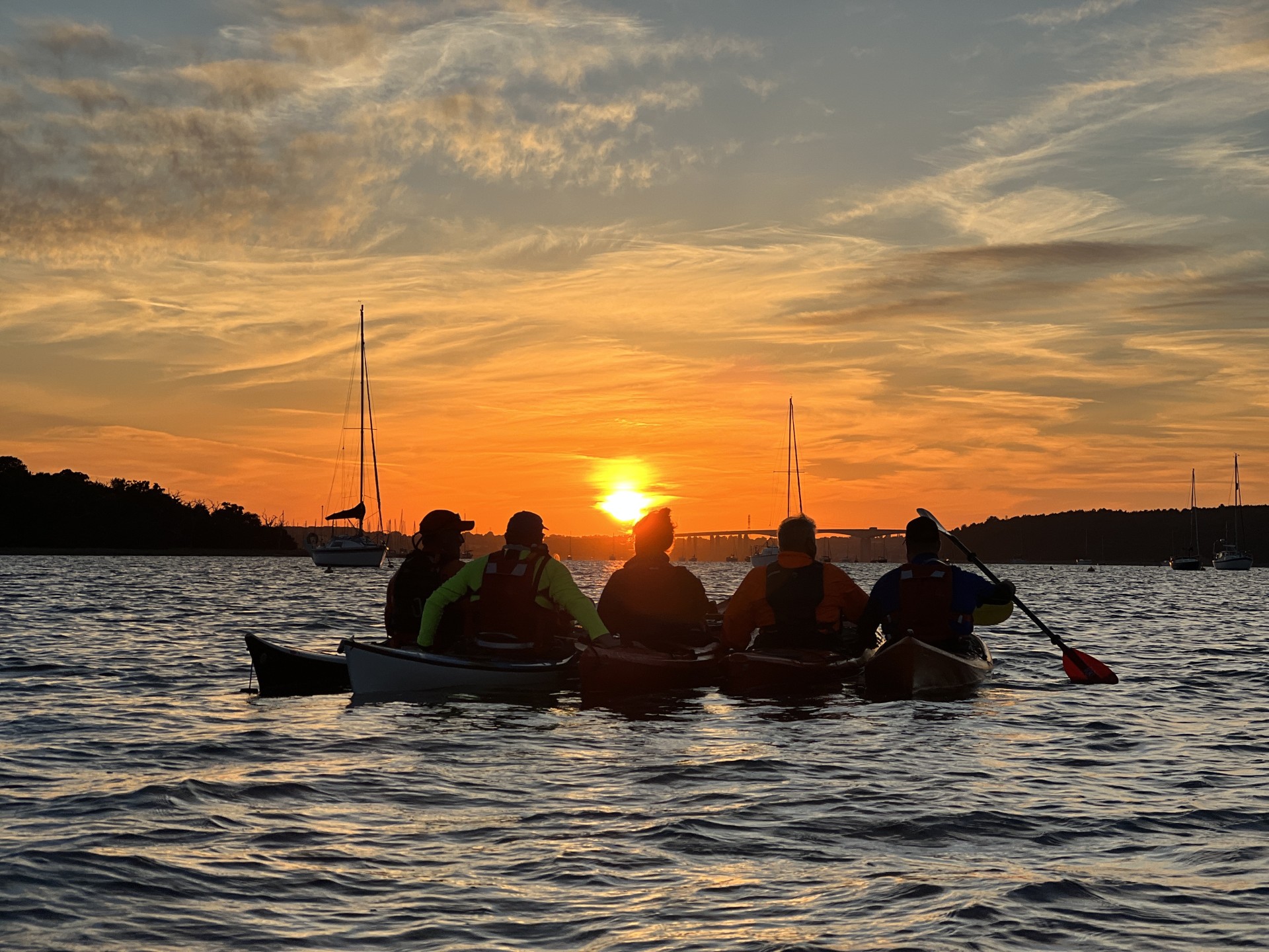 Rafted sea kayakers with a Suffolk sunset.