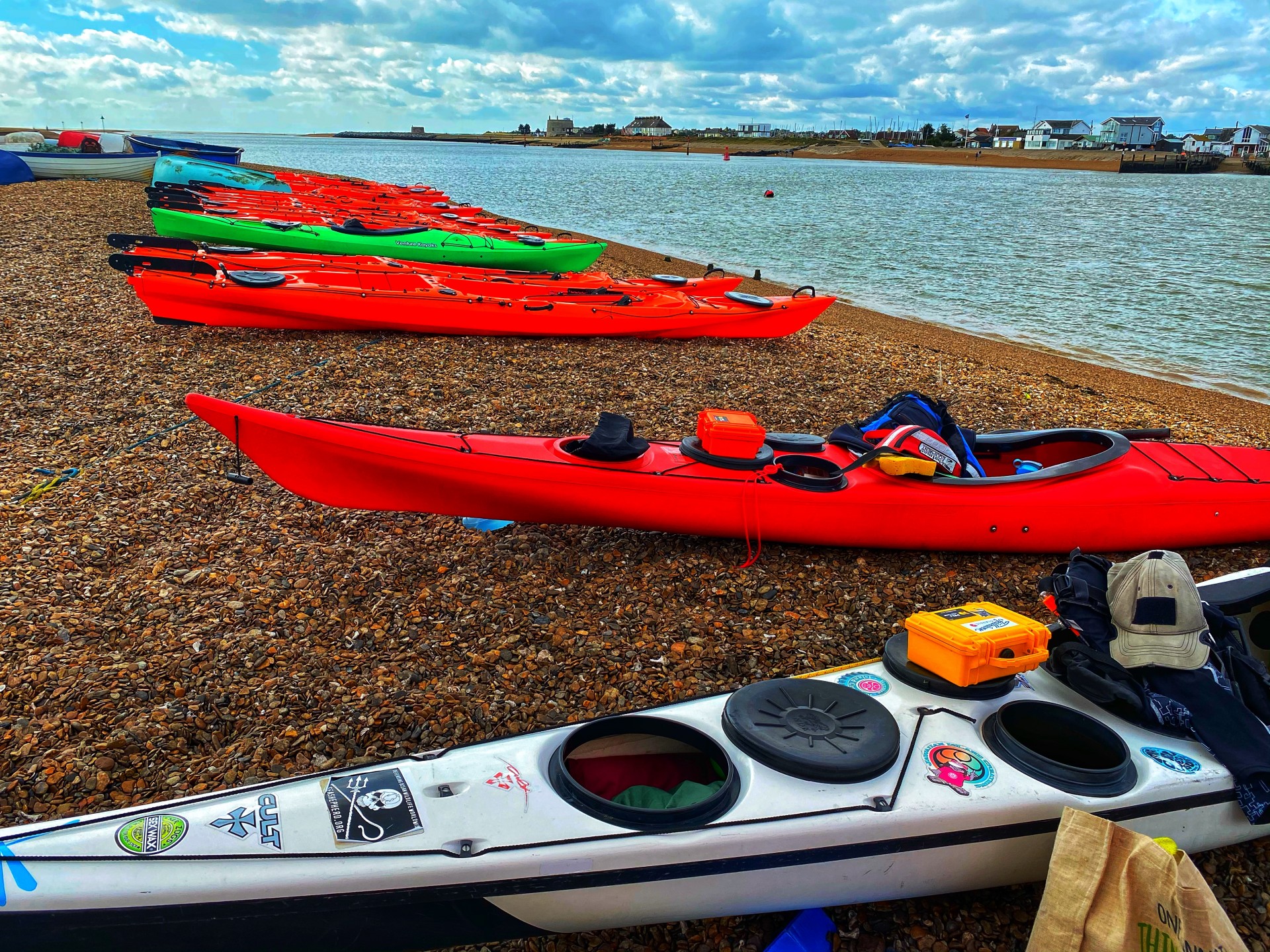 NDK Sport in Red with black decklines with an NDK Explorer Sea Kayak in the foreground