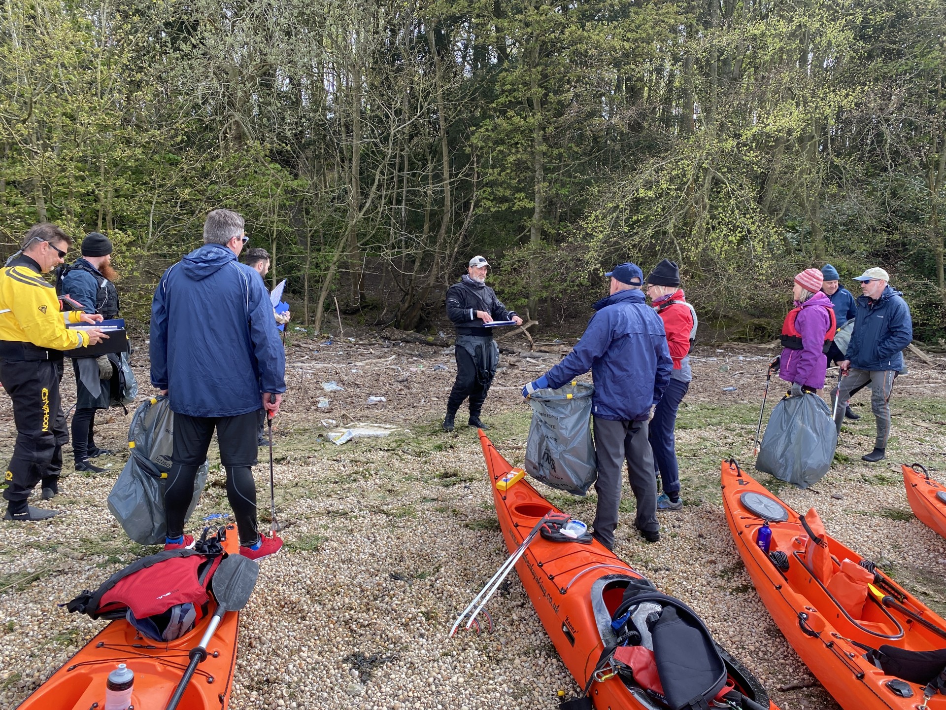 A kayak Guide briefing volunteers prior to cleaning a beach of trash.