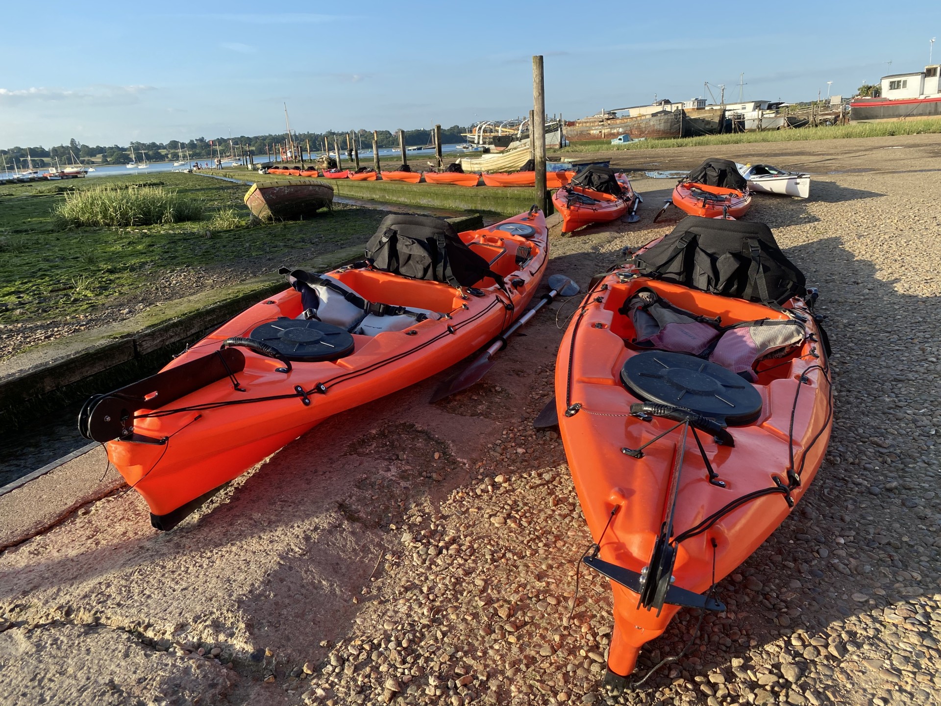 Orange kayaks on the slipway ready for launch.