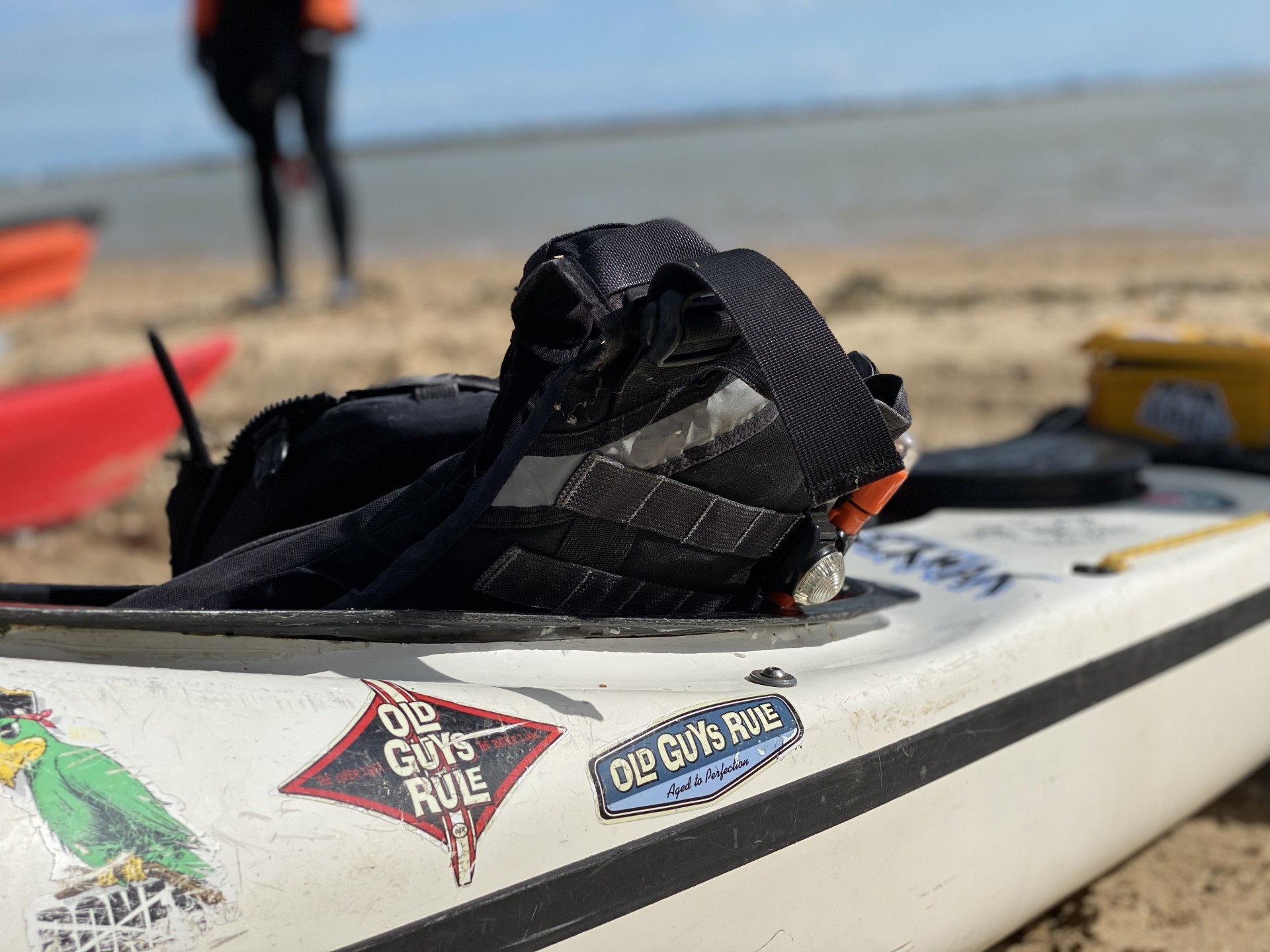 Buoyancy aid and marine VHF radio lying on a sea kayak.