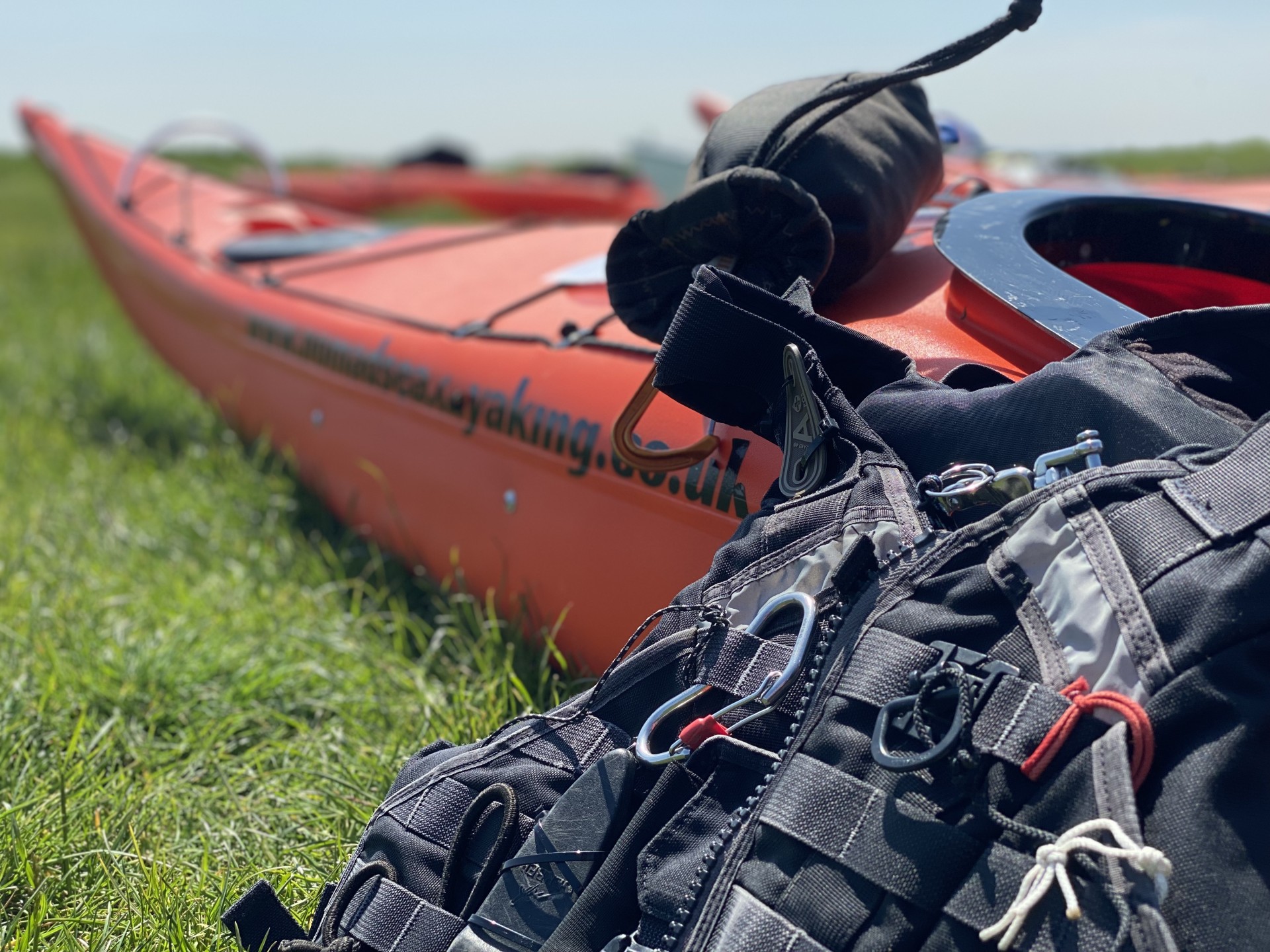 /storage/A Red Sea kayak with black buoyancy aid ready to launch with NOMAD Sea Kayaking.