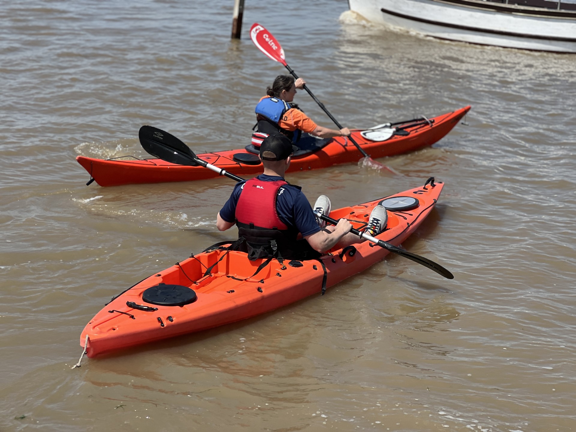 Two red kayaks on the Deben estuary with NOMAD Sea Kayaking.