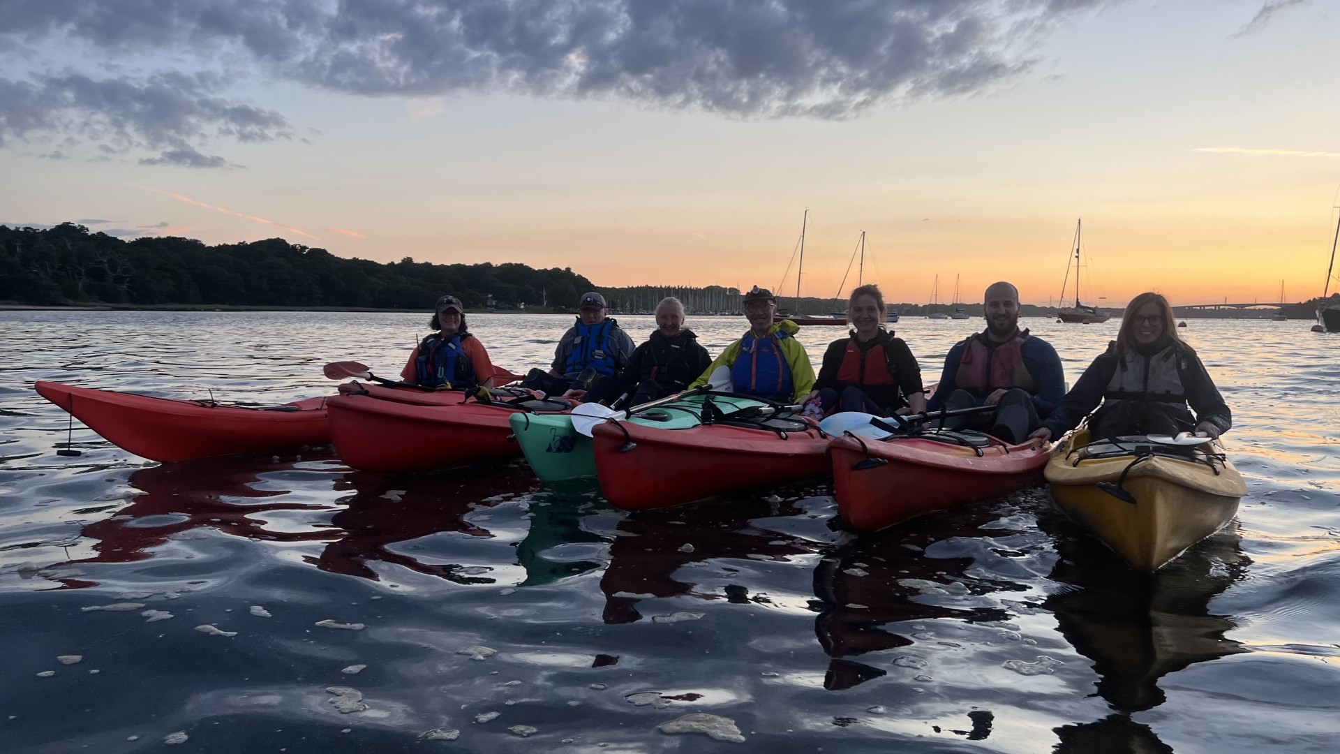 Sea kayakers on the water at sunset.