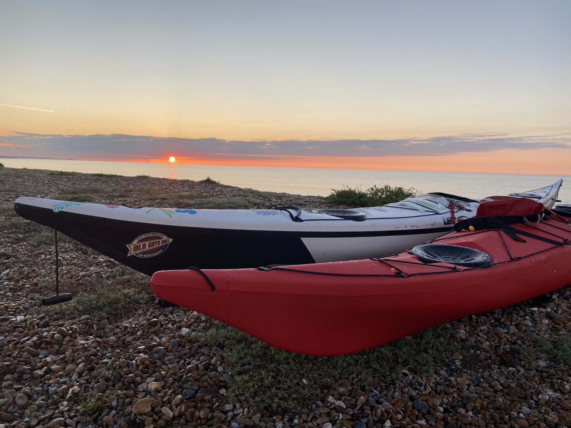 Sunset over beached sea kayaks on the Suffolk all inclusive wild camping weekend