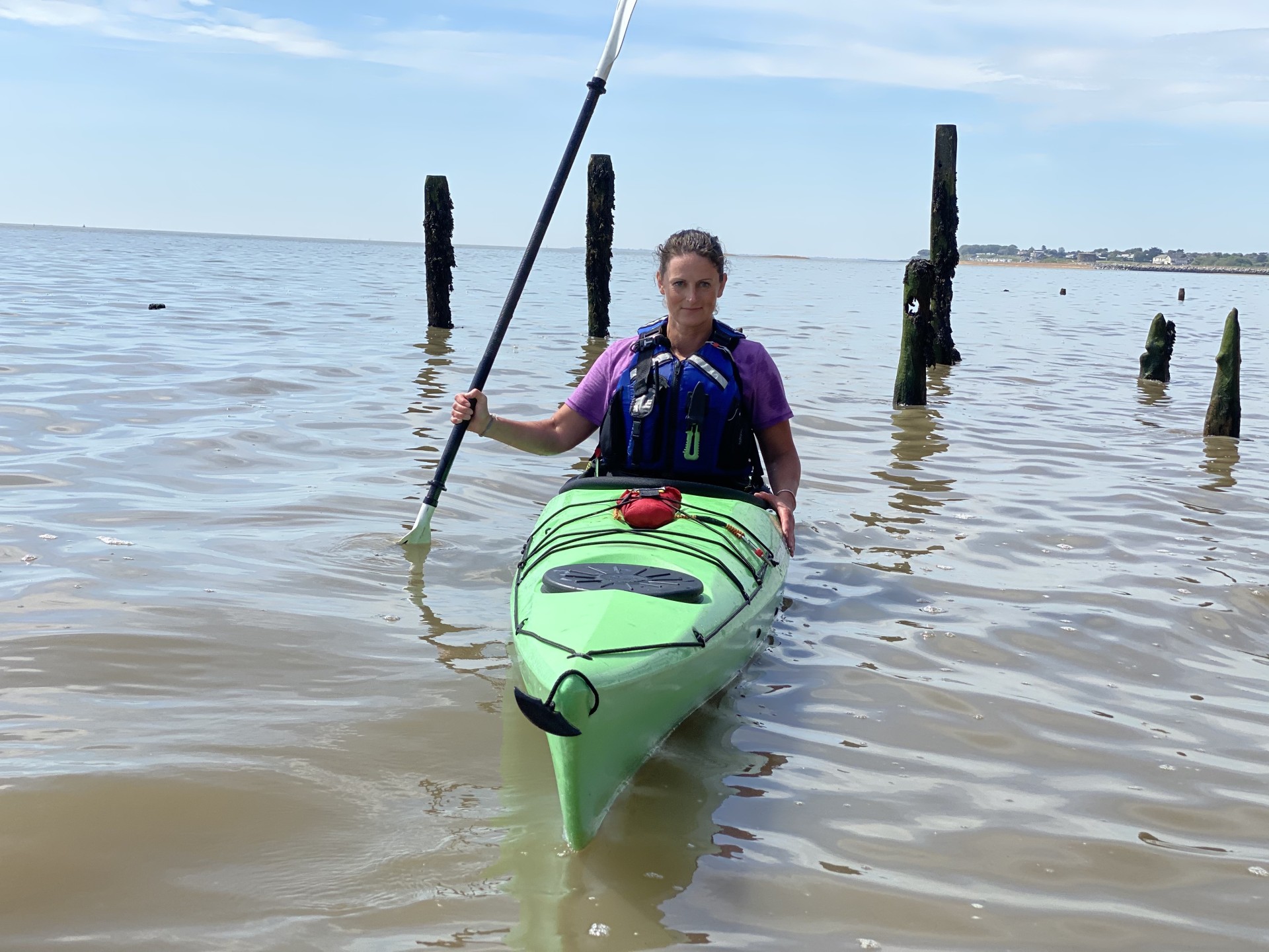 Lady smiling from her sea kayak in Suffolk.