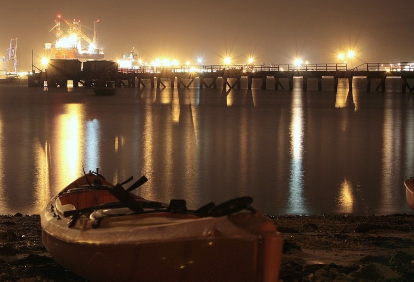 Sit-on-top kayak on a beach at night with Harwich in the background.