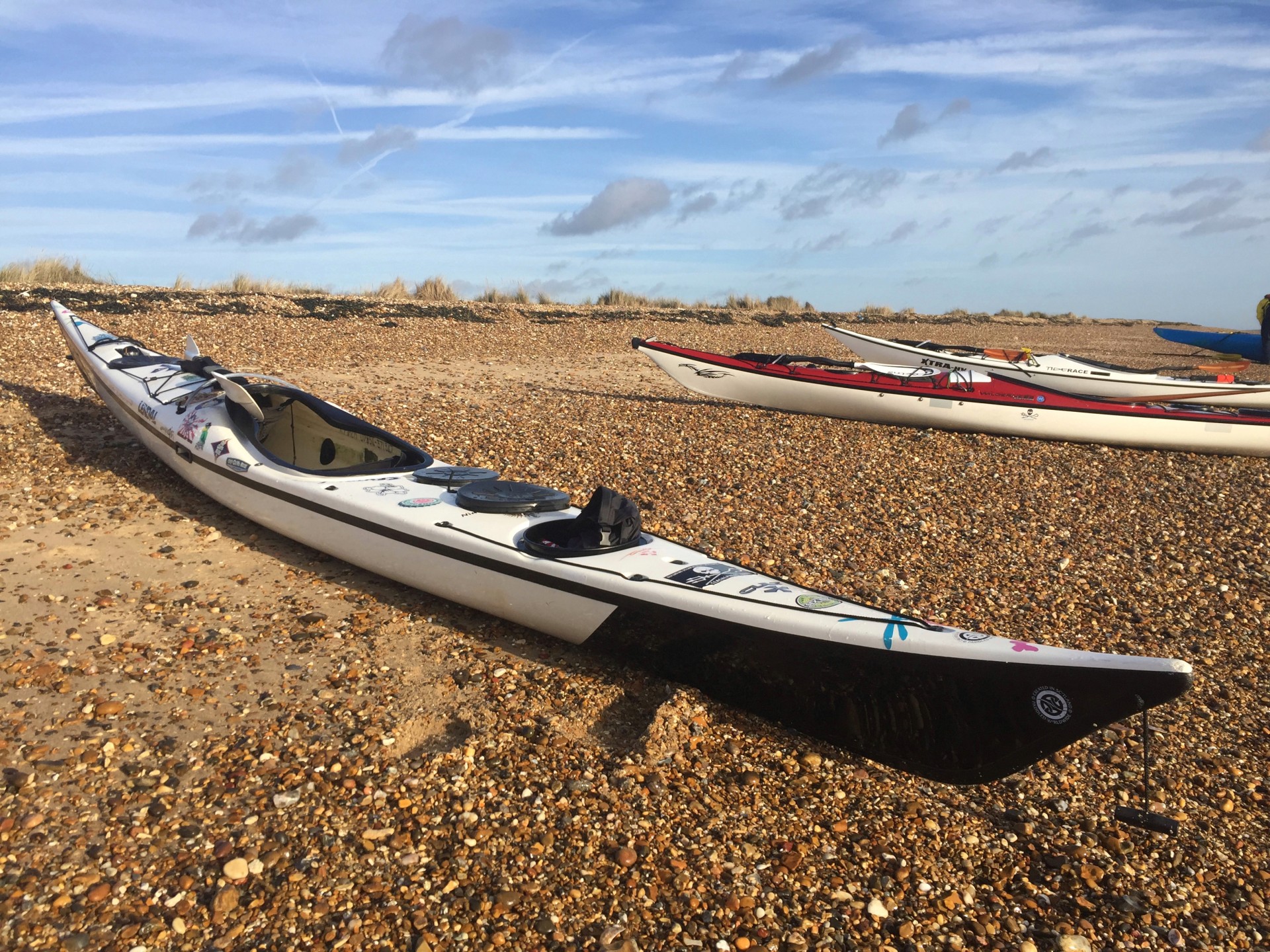 Sea kayaks on a sandy shingle beach near Shingle Street Suffolk.