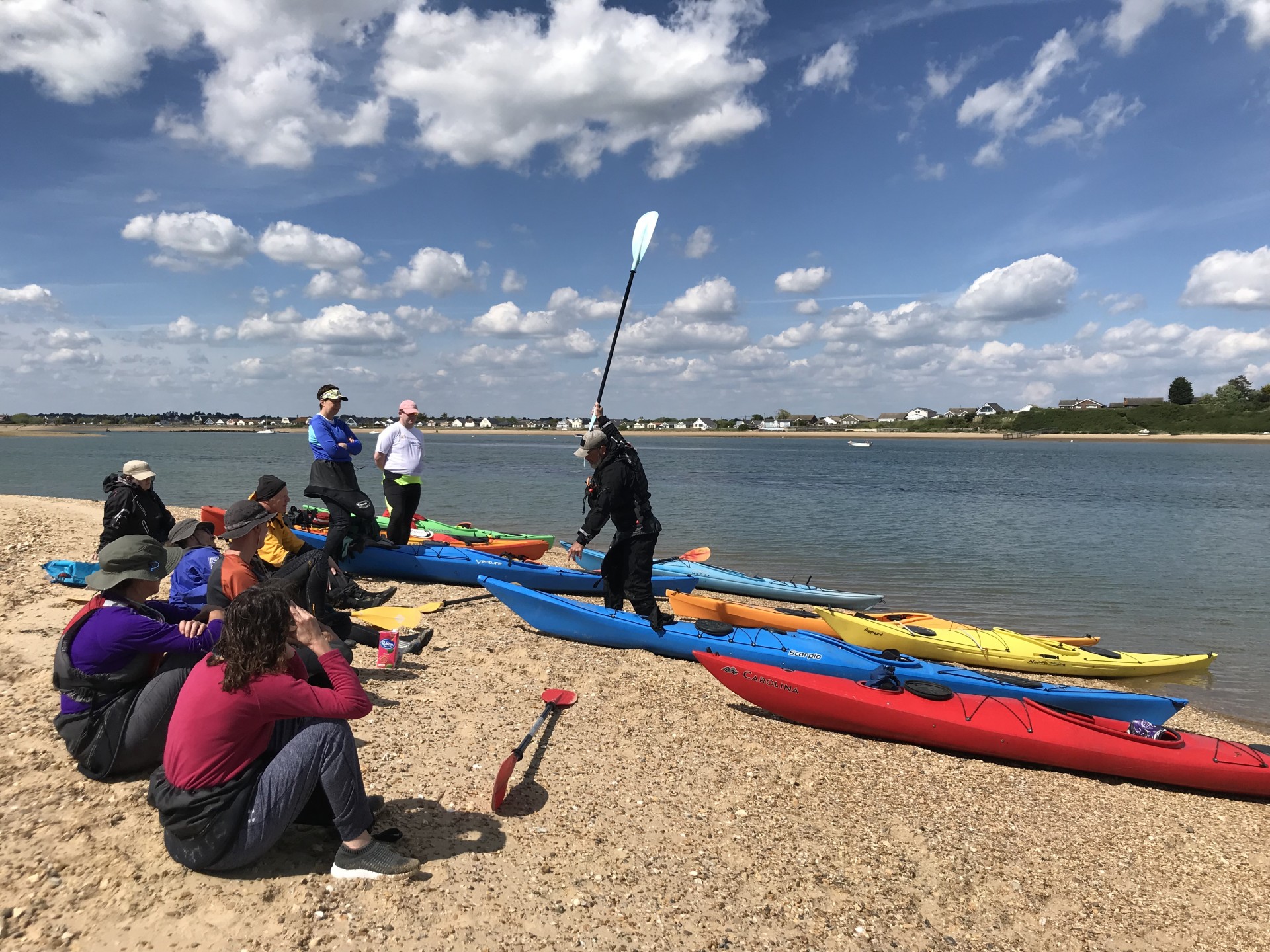 Guests sitting on a sandy beach in sunshine on a corporate team building event