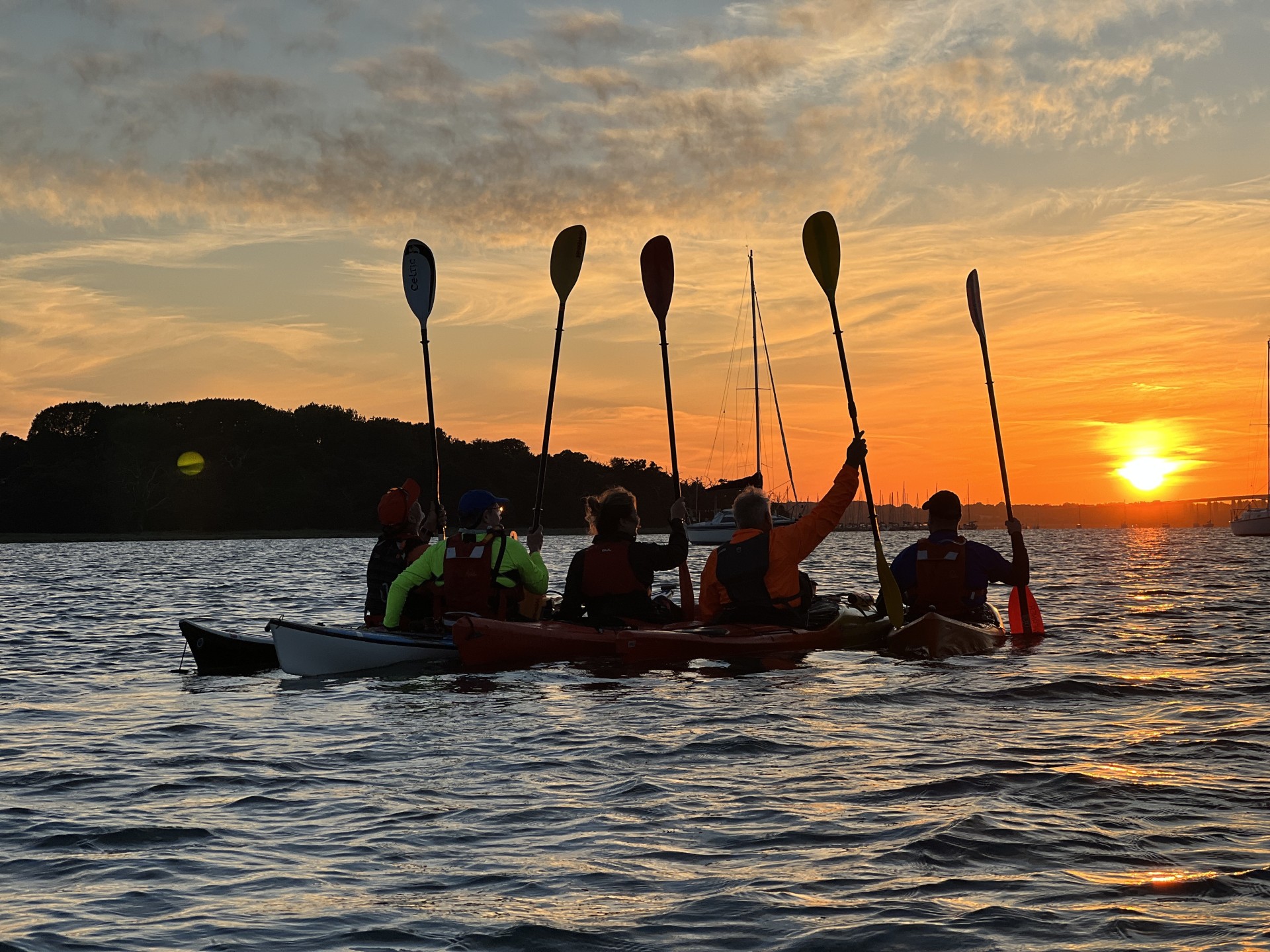 Kayakers watching a sunset.