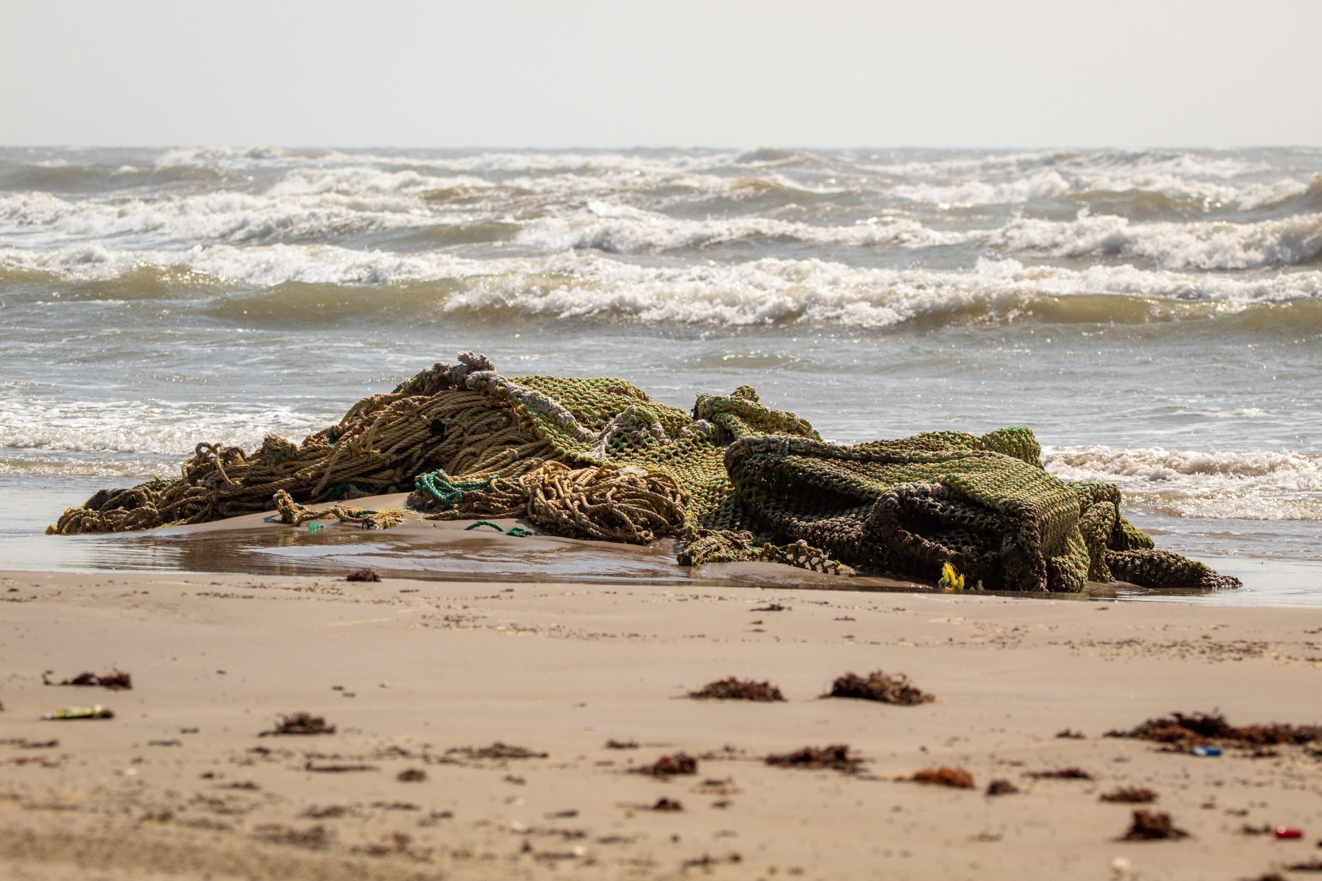 A huge pile of discarded fishing nets washed up on a beach