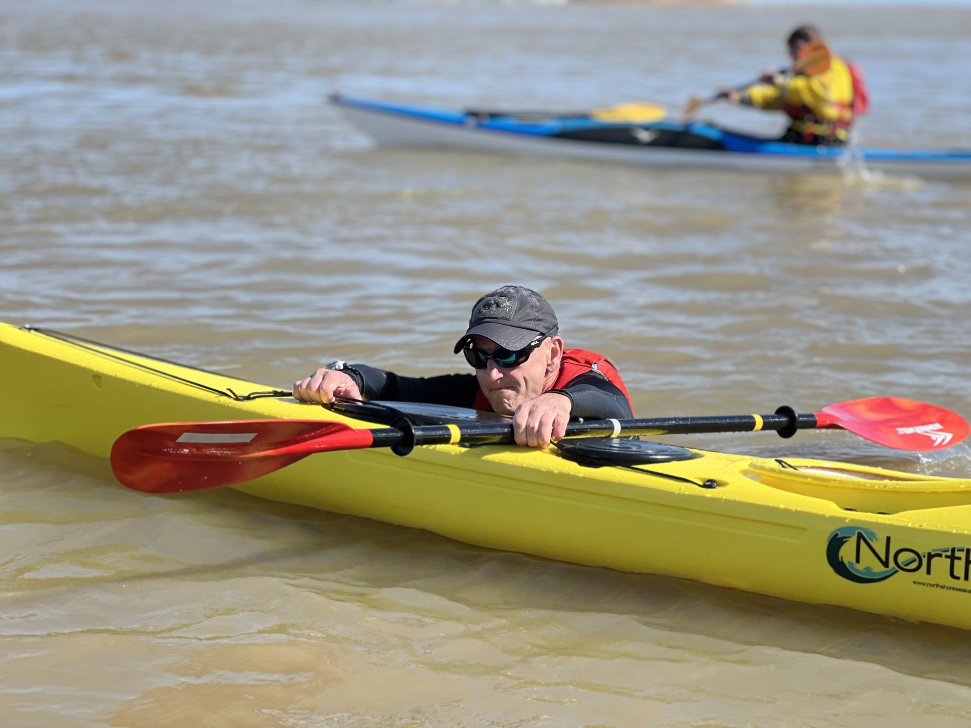 Preparing to re-enter his sea kayak with NOMAD Sea Kayaking.