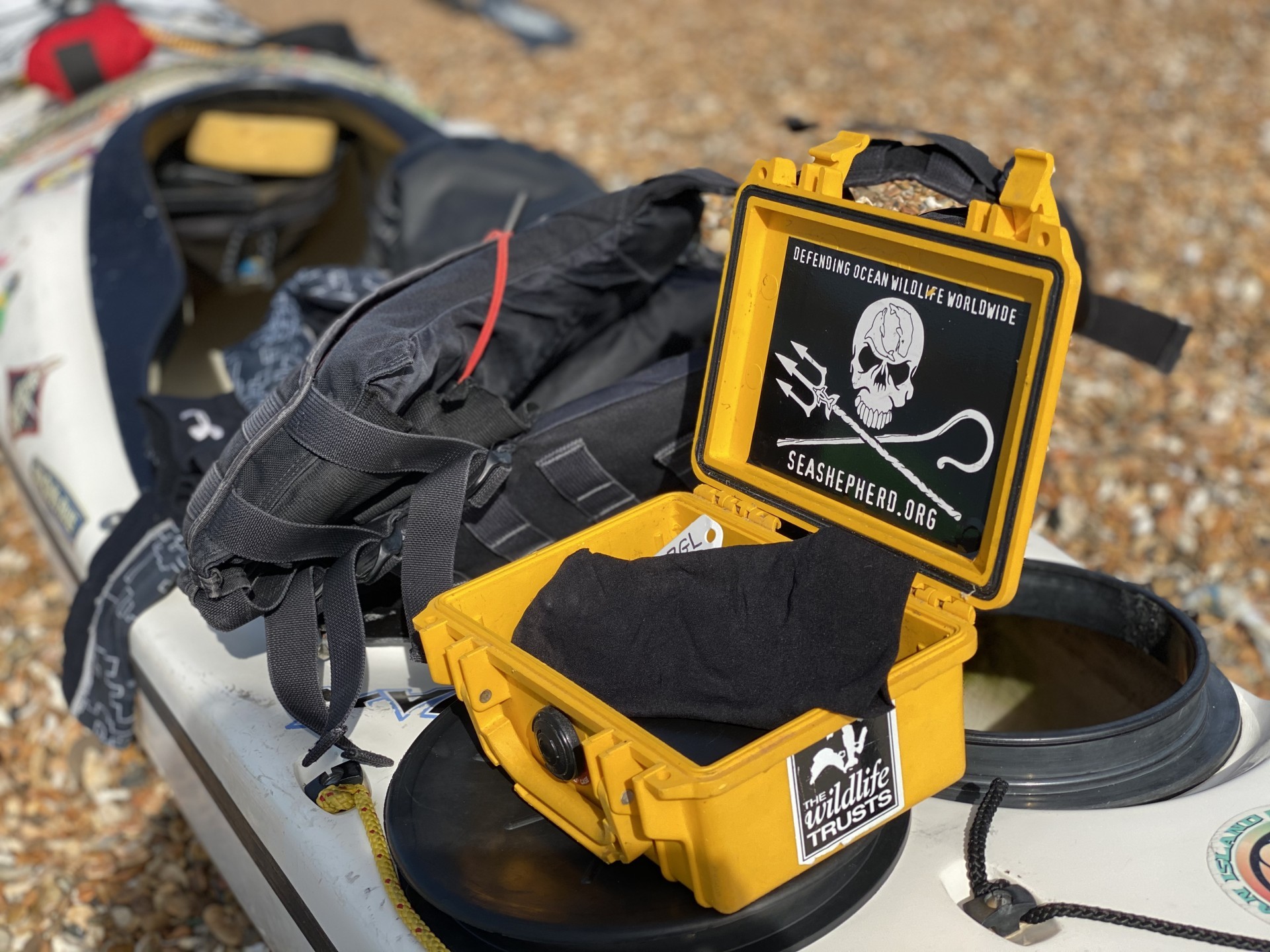 A Peli box for waterproofing valuable items sitting open on a sea kayak.