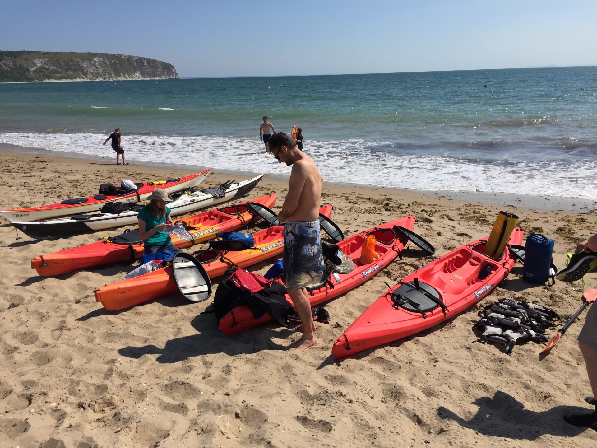 Kayaks line a sandy beach on the Dorset Jurassic coast