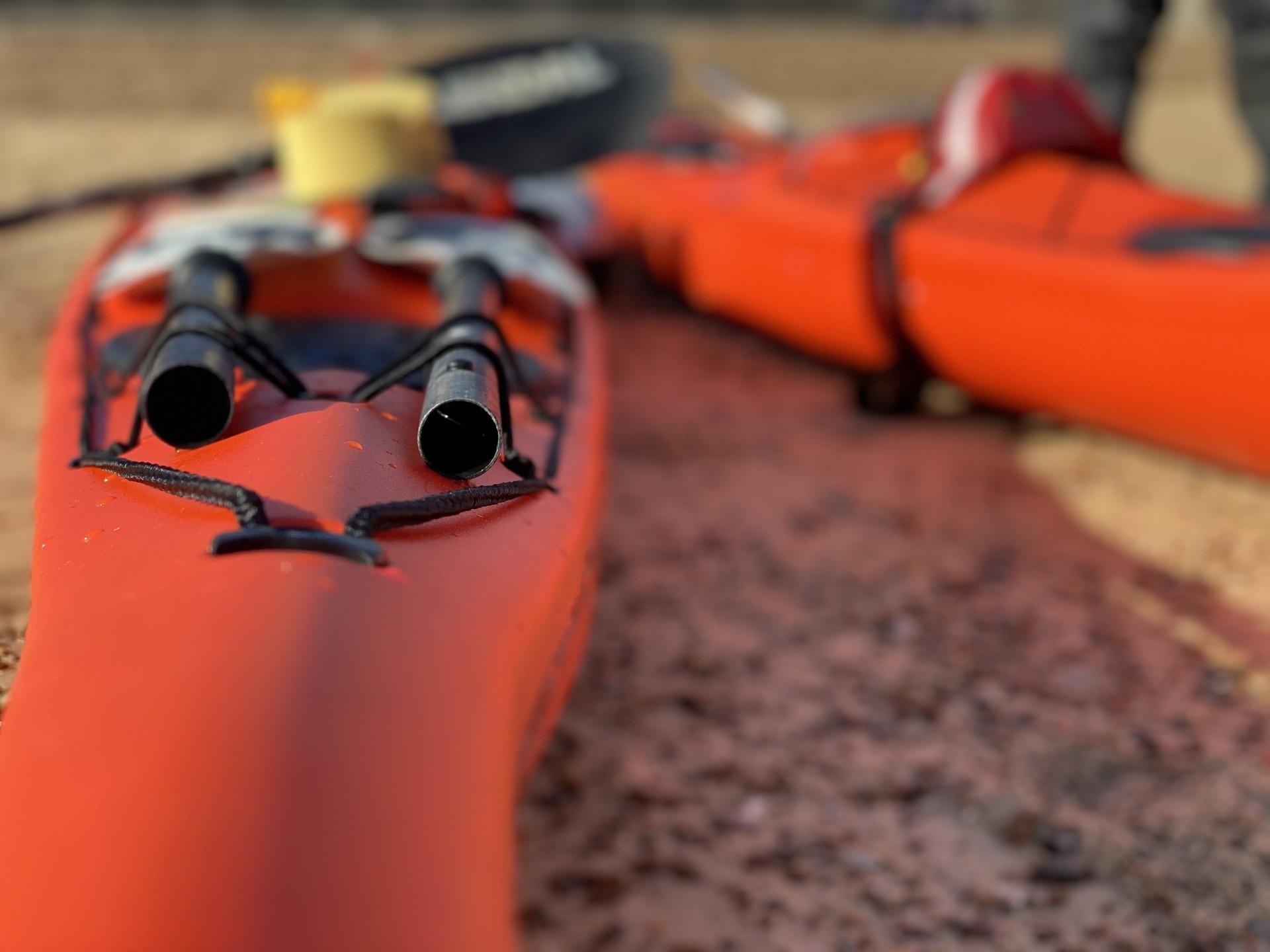 Two orange sea kayaks on a beach for team building for businesses.