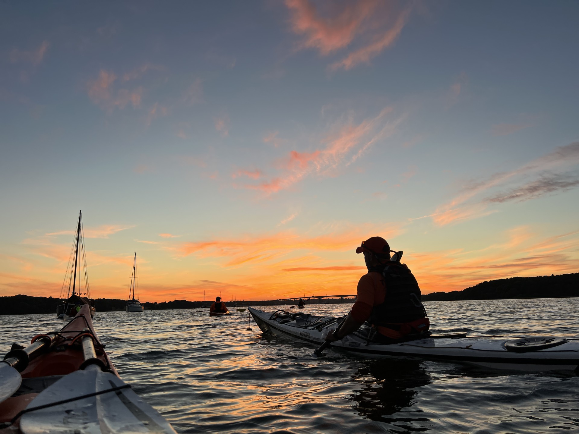 Sea kayakers at sunset with NOMAD Sea Kayaking.