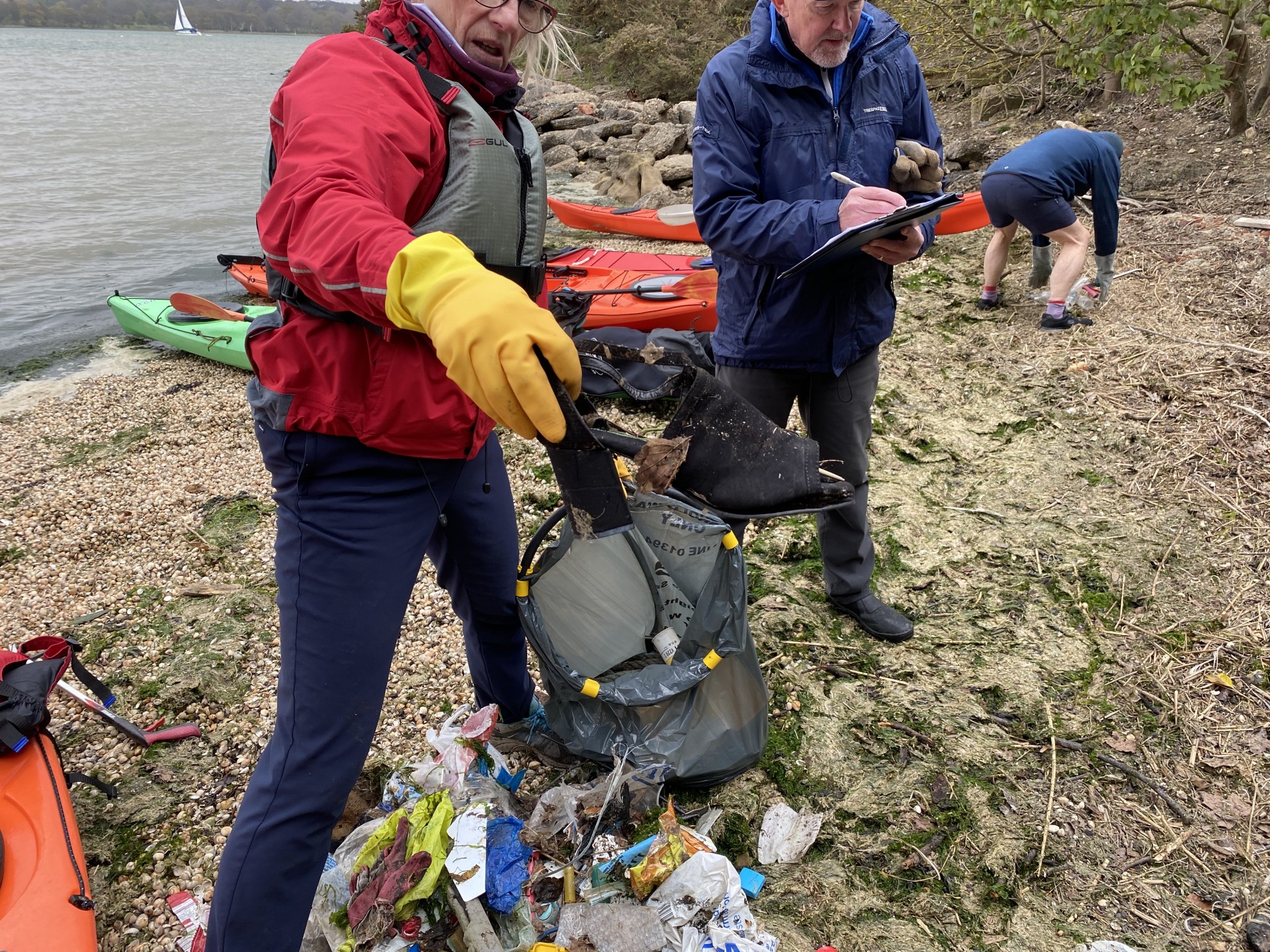 Refuse collection by kayakers on a Suffolk beach.