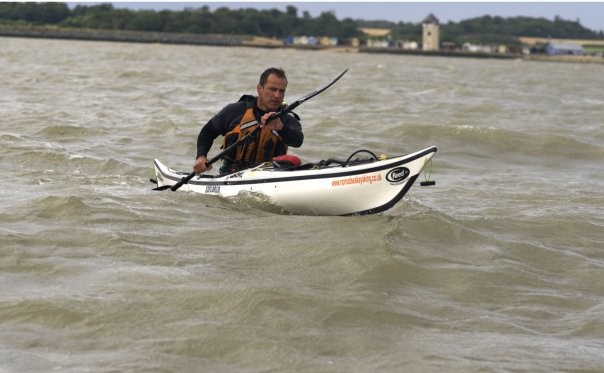 Sea kayaker paddling in deep water off Brightlingsea, Essex.