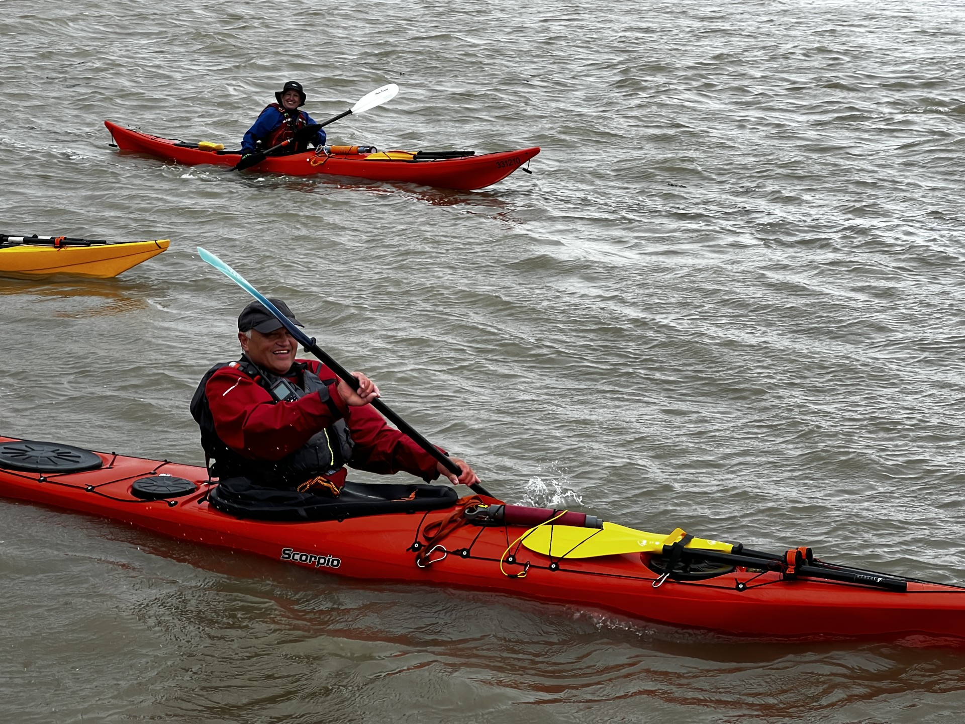 Smiling guests in sea kayaks.