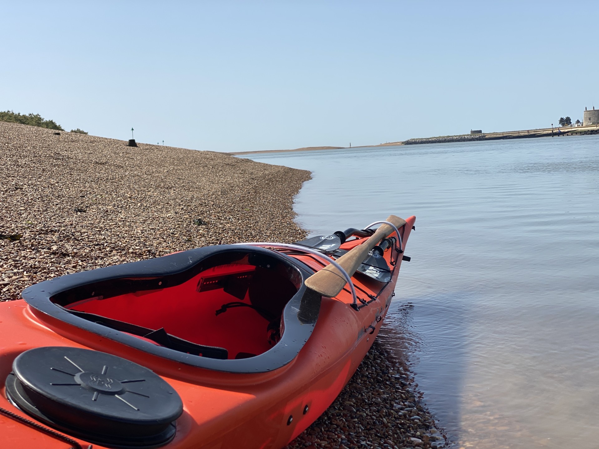 An orange sea kayak on the beach at the Deben shoals with NOMAD Sea Kayaking.