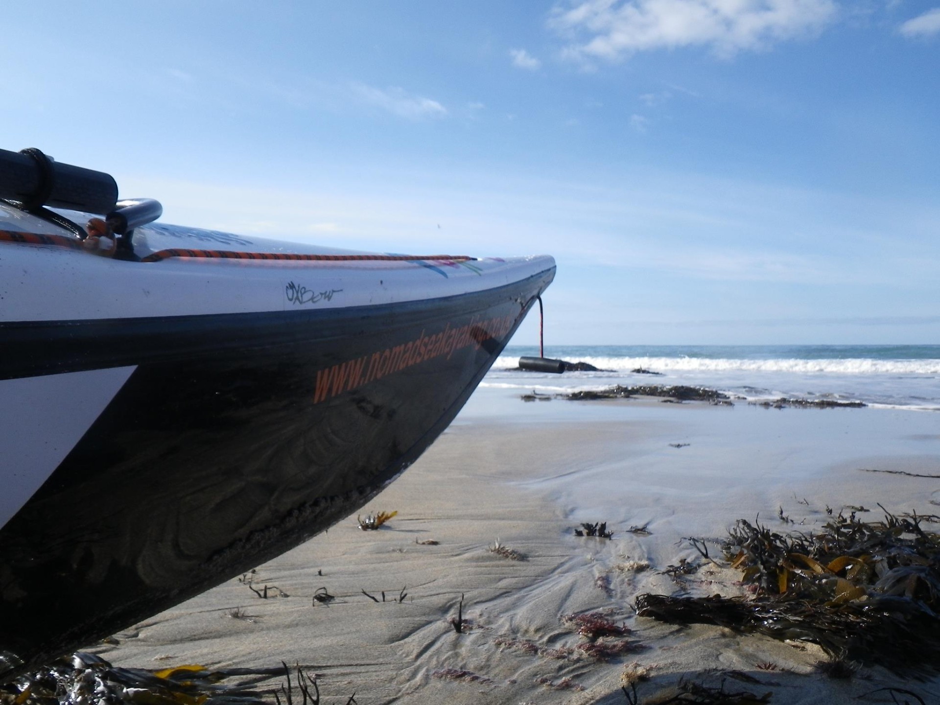 Nose of a sea kayak on a sandy beach in Cornwall.