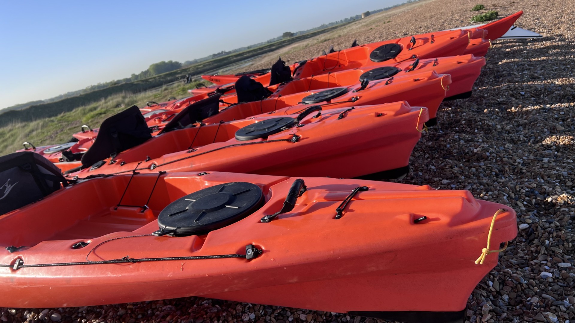 Orange sit-on-top kayaks with NOMAD Sea Kayaking.