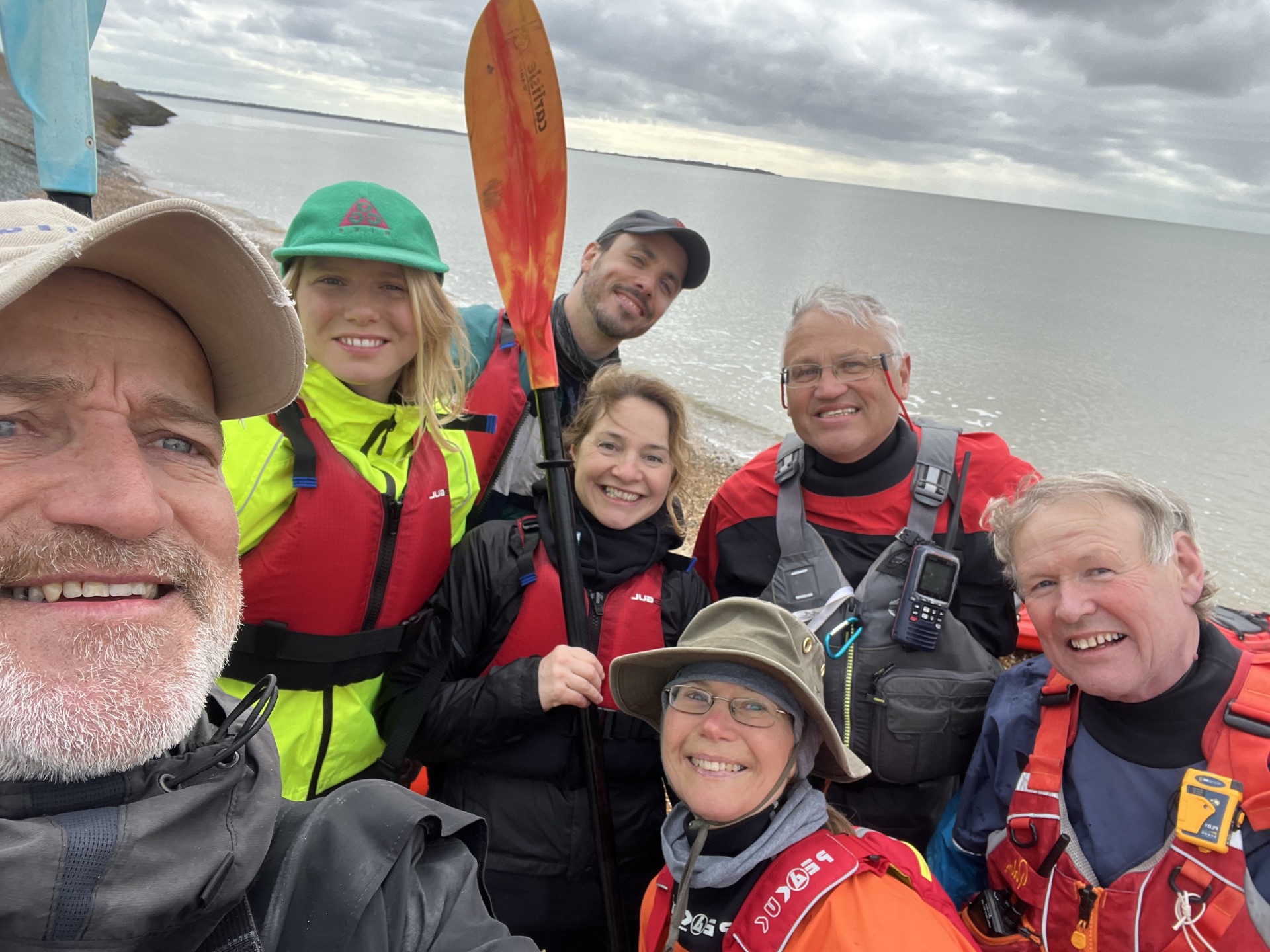 A happy group of smiling kayakers with NOMAD Sea Kayaking.