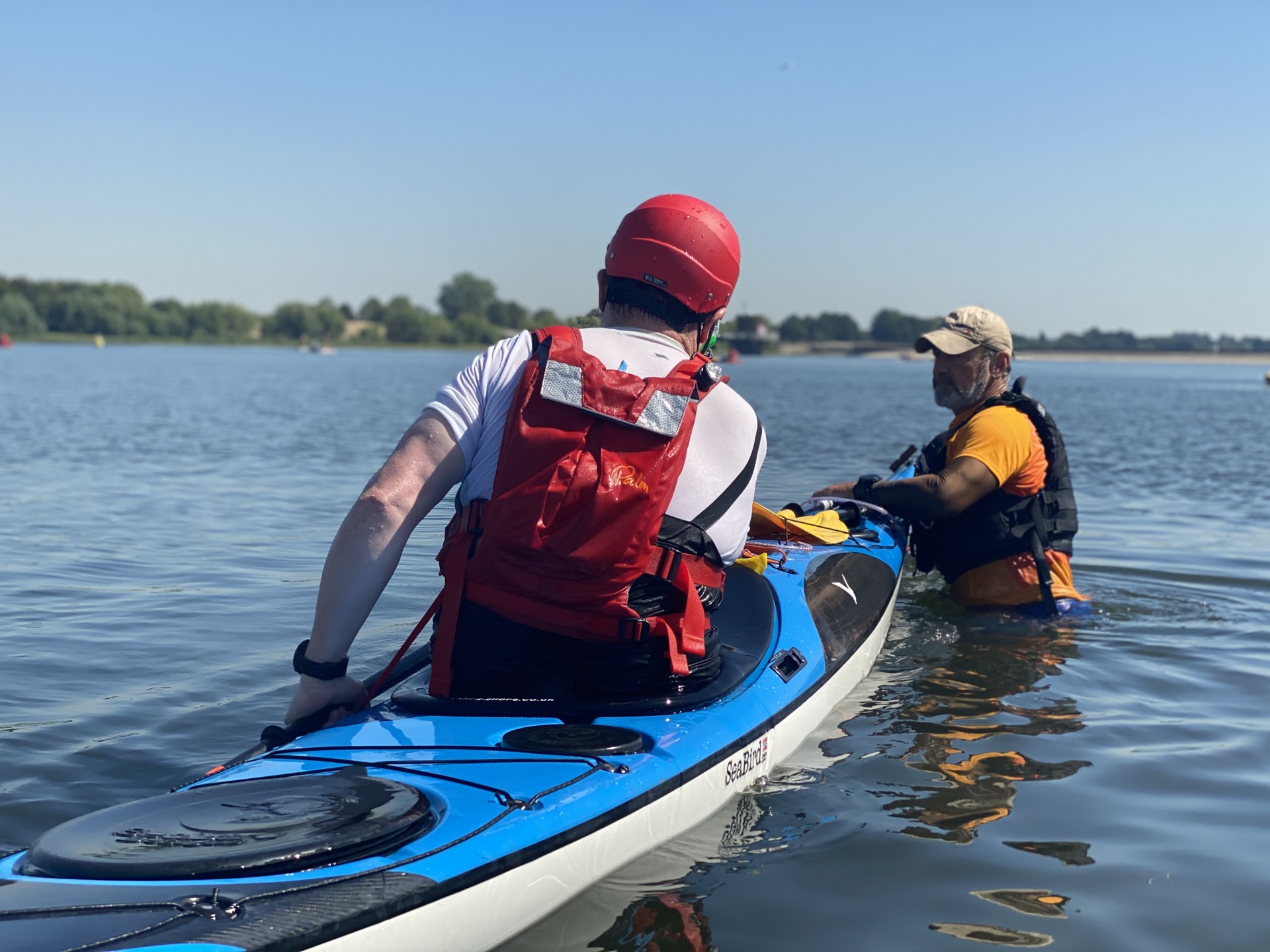 Setting up a sea kayak for an eskimo sweep roll on waist deep water.