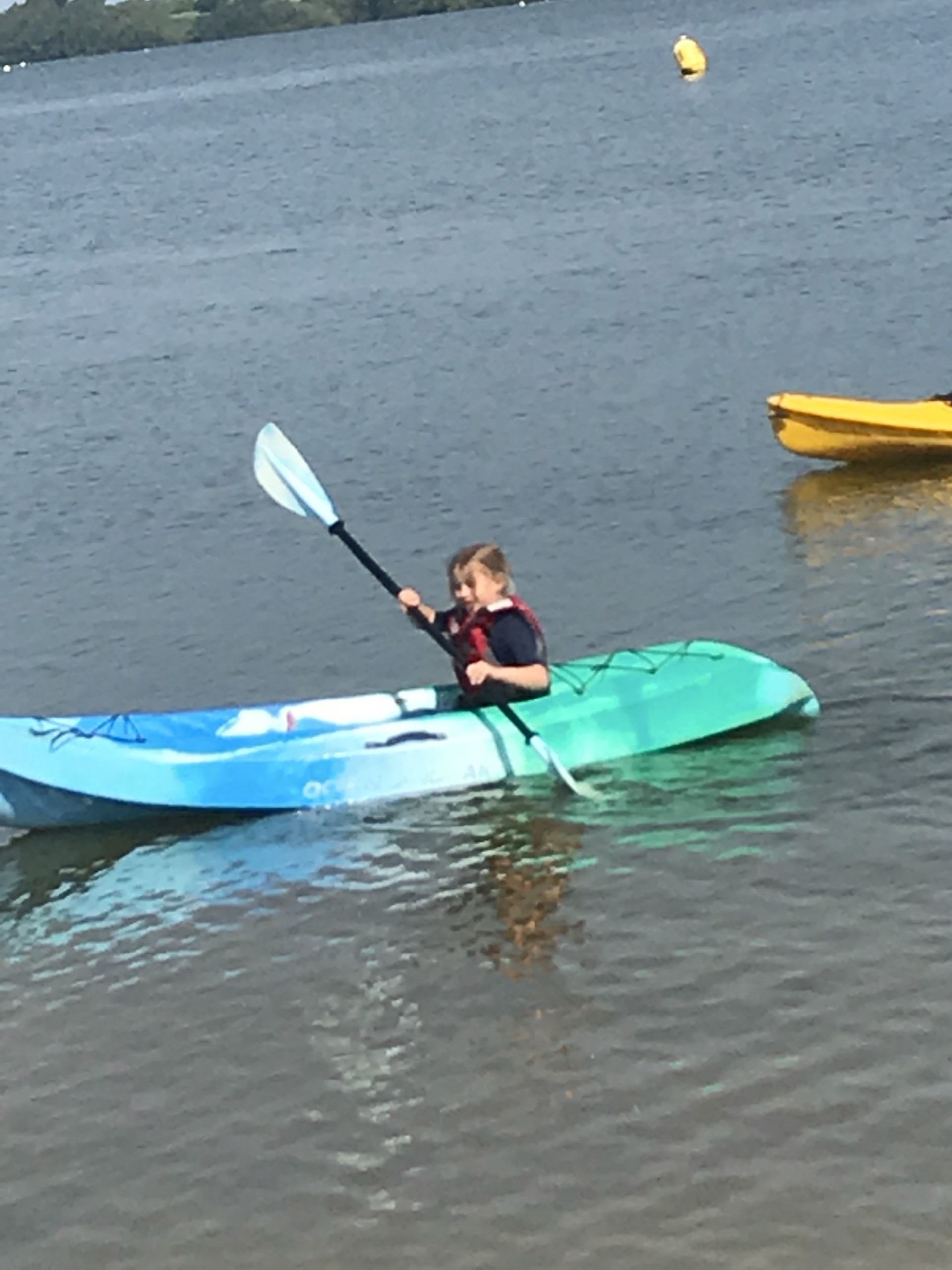 Small girl having fun on a sit-on-top kayak on the water