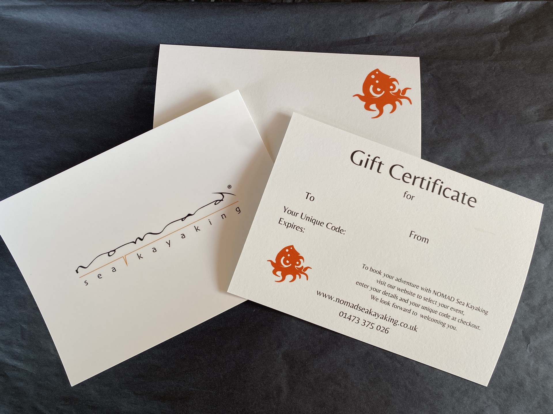 Quality white card gift vouchers with black wrapping & orange accents.