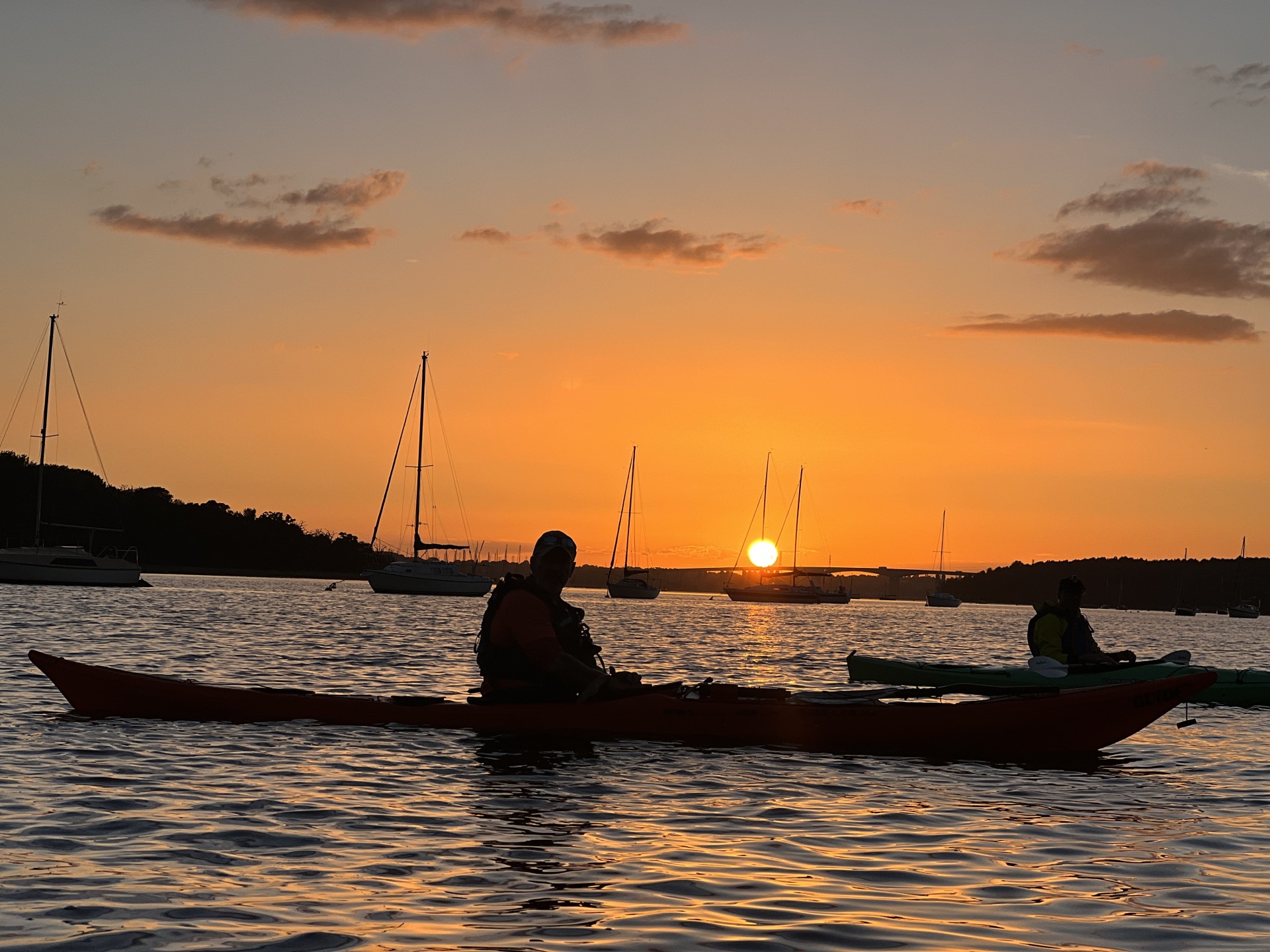 Sea kayakers at sunset on the Orwell estuary with NOMAD Sea Kayaking.