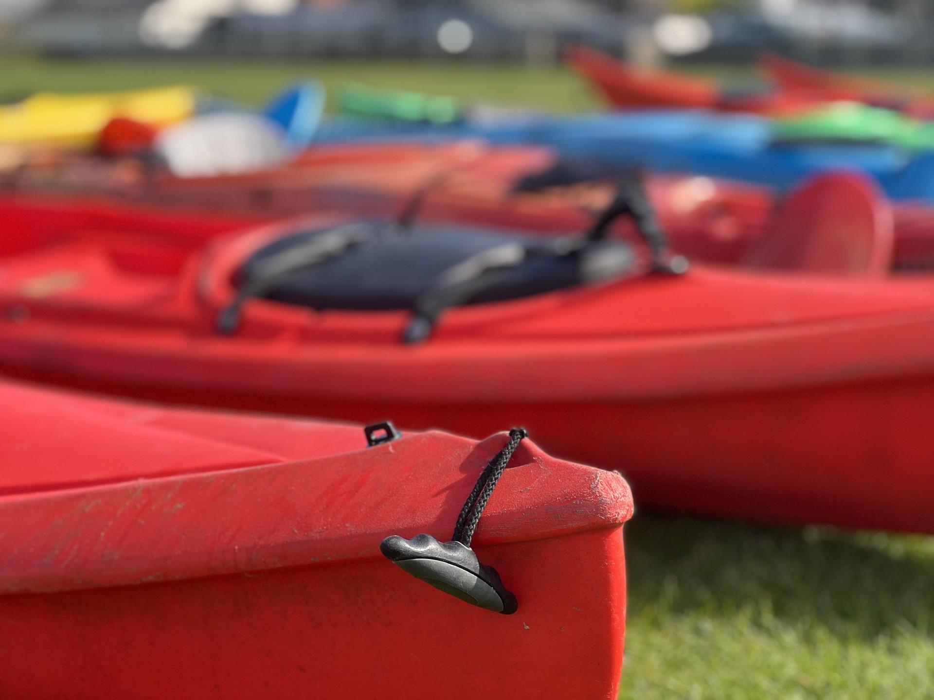 The stern of a red kayak with NOMAD Sea Kayaking.