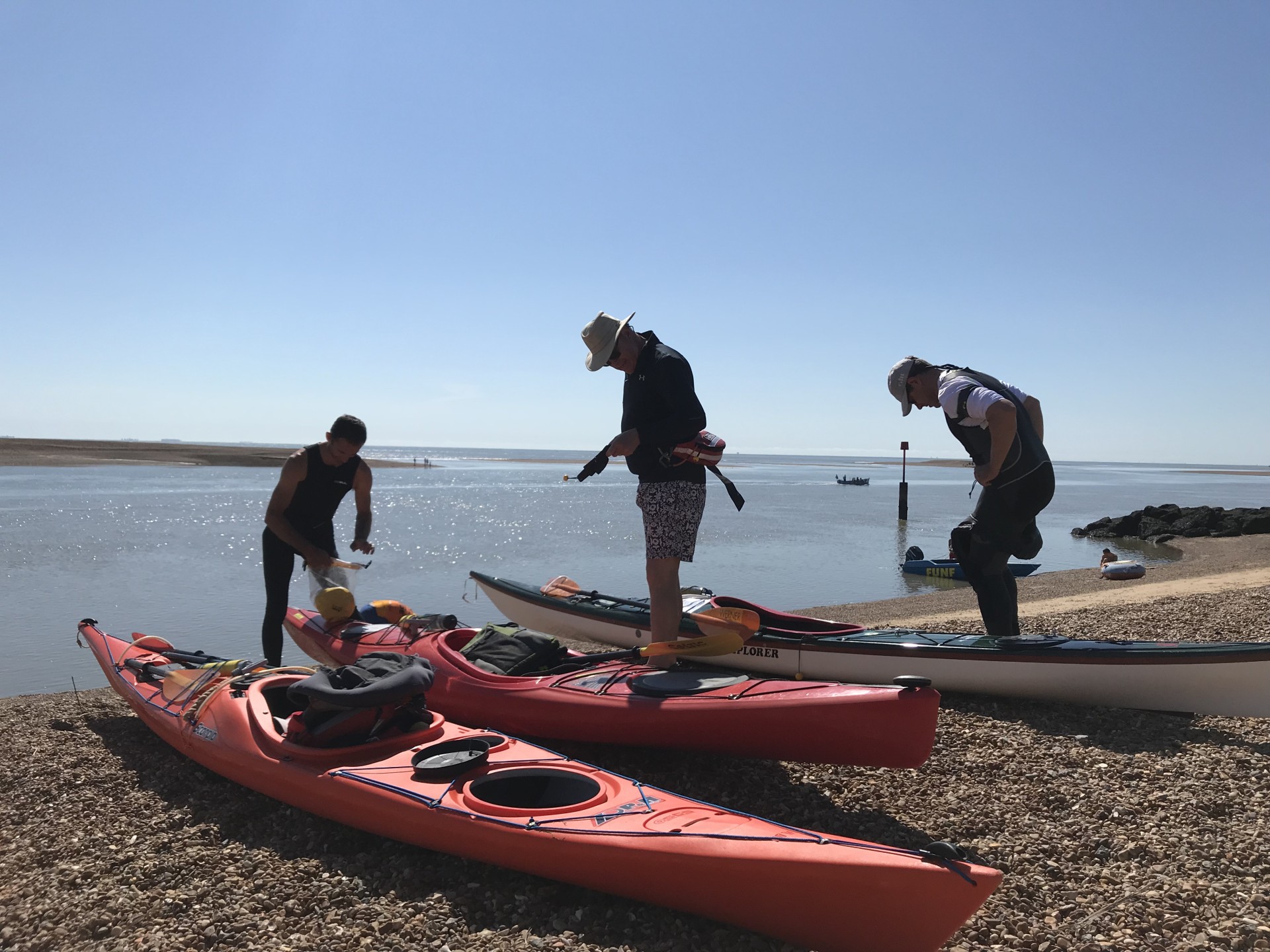 Preparing kayaks on a shingle beach in Suffolk.