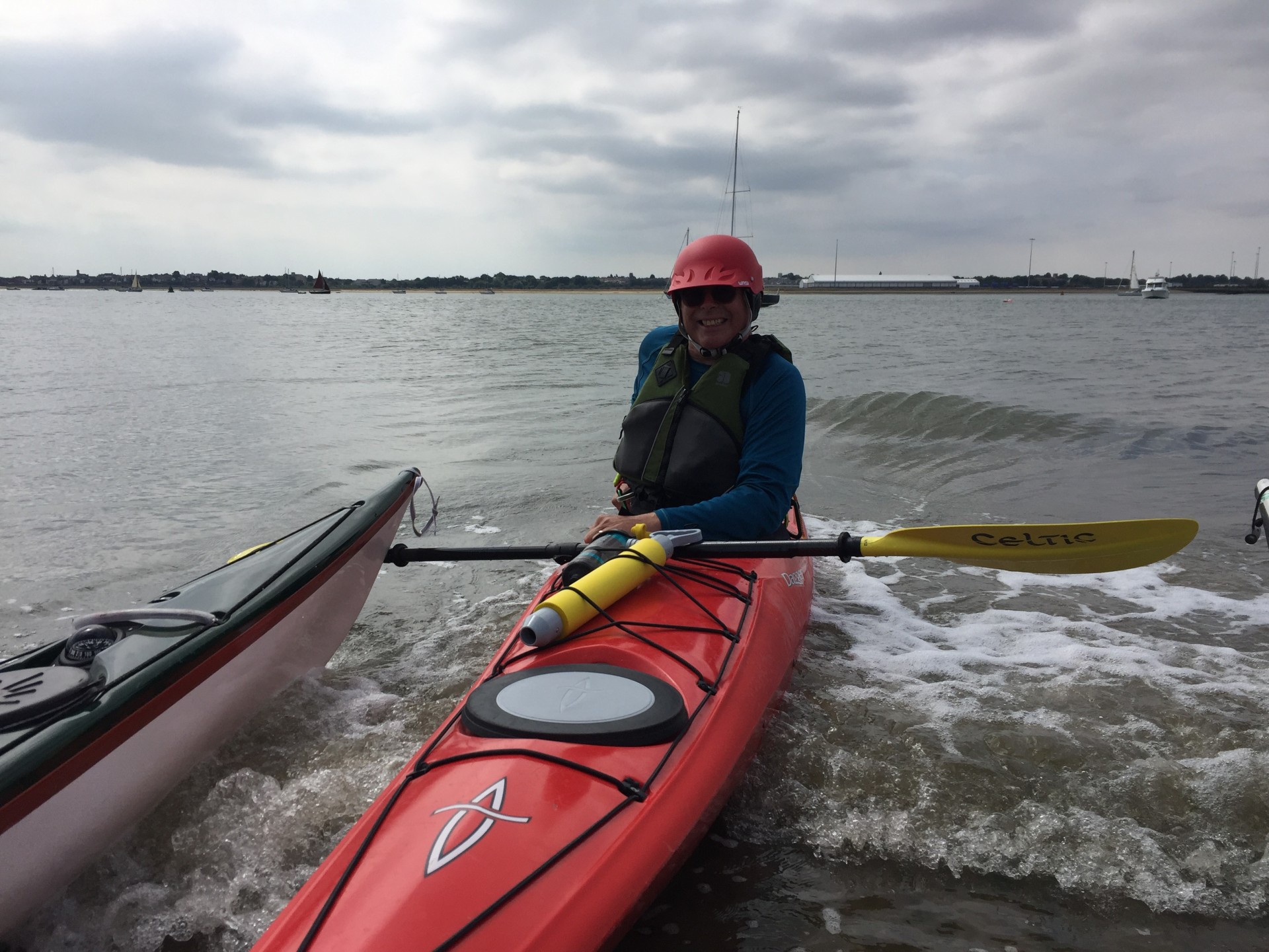 Sea kayaker putting applying her spraydeck.