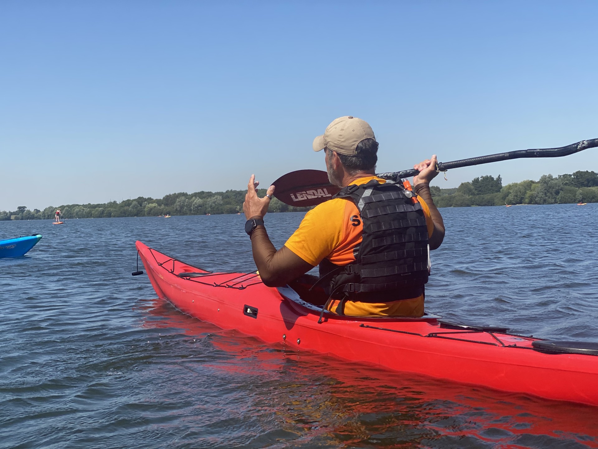 Coach teaching on the water from a red sea kayak.
